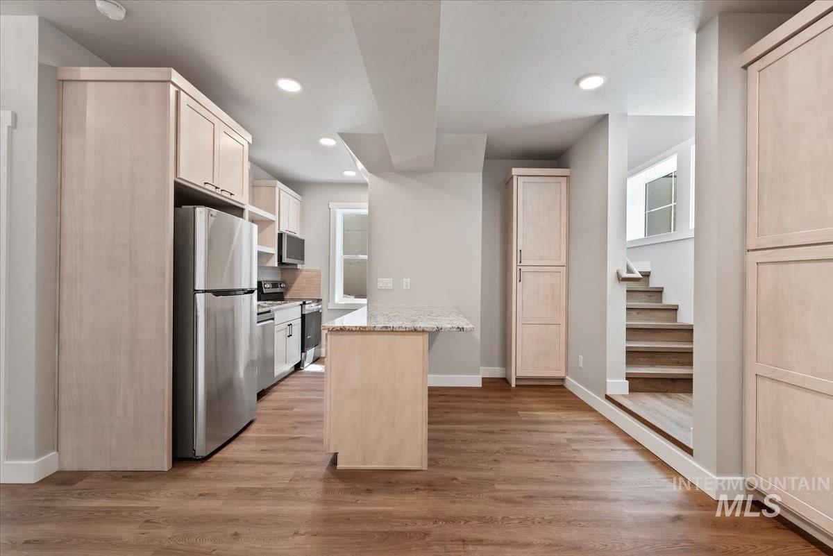 Kitchen with appliances with stainless steel finishes, light brown cabinets, recessed lighting, and light wood-style flooring