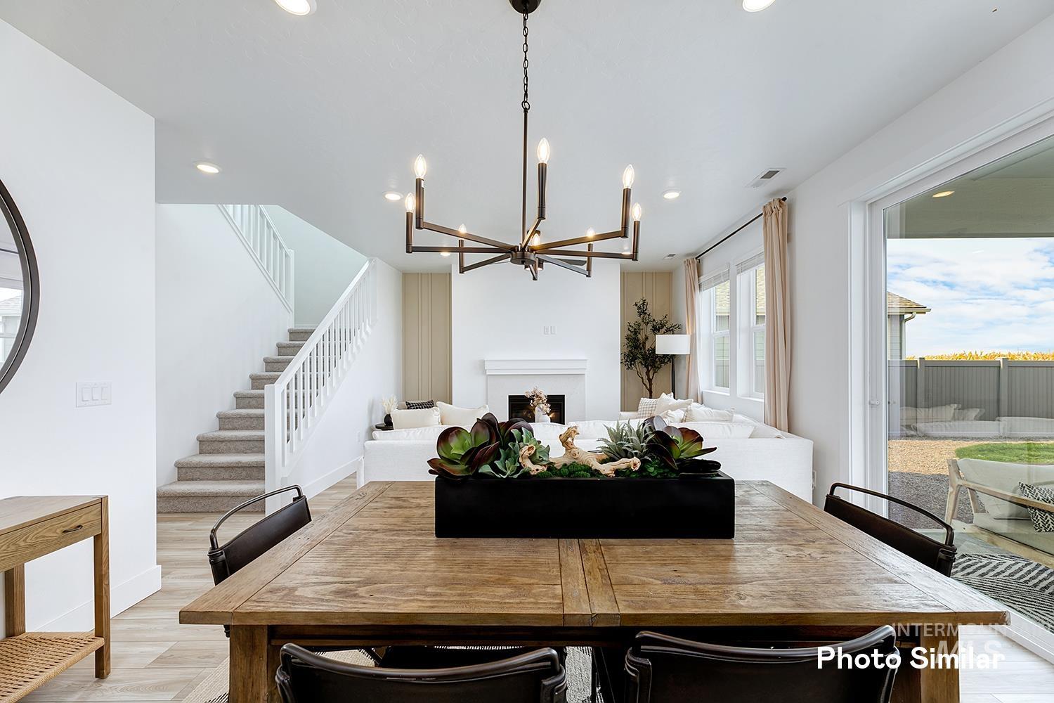 Dining room with a fireplace, stairway, recessed lighting, light wood-style flooring, and a chandelier
