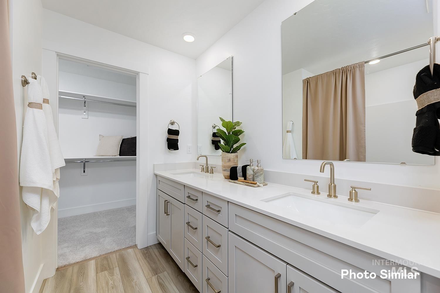 Full bathroom with light wood-type flooring, double vanity, a walk in closet, and recessed lighting