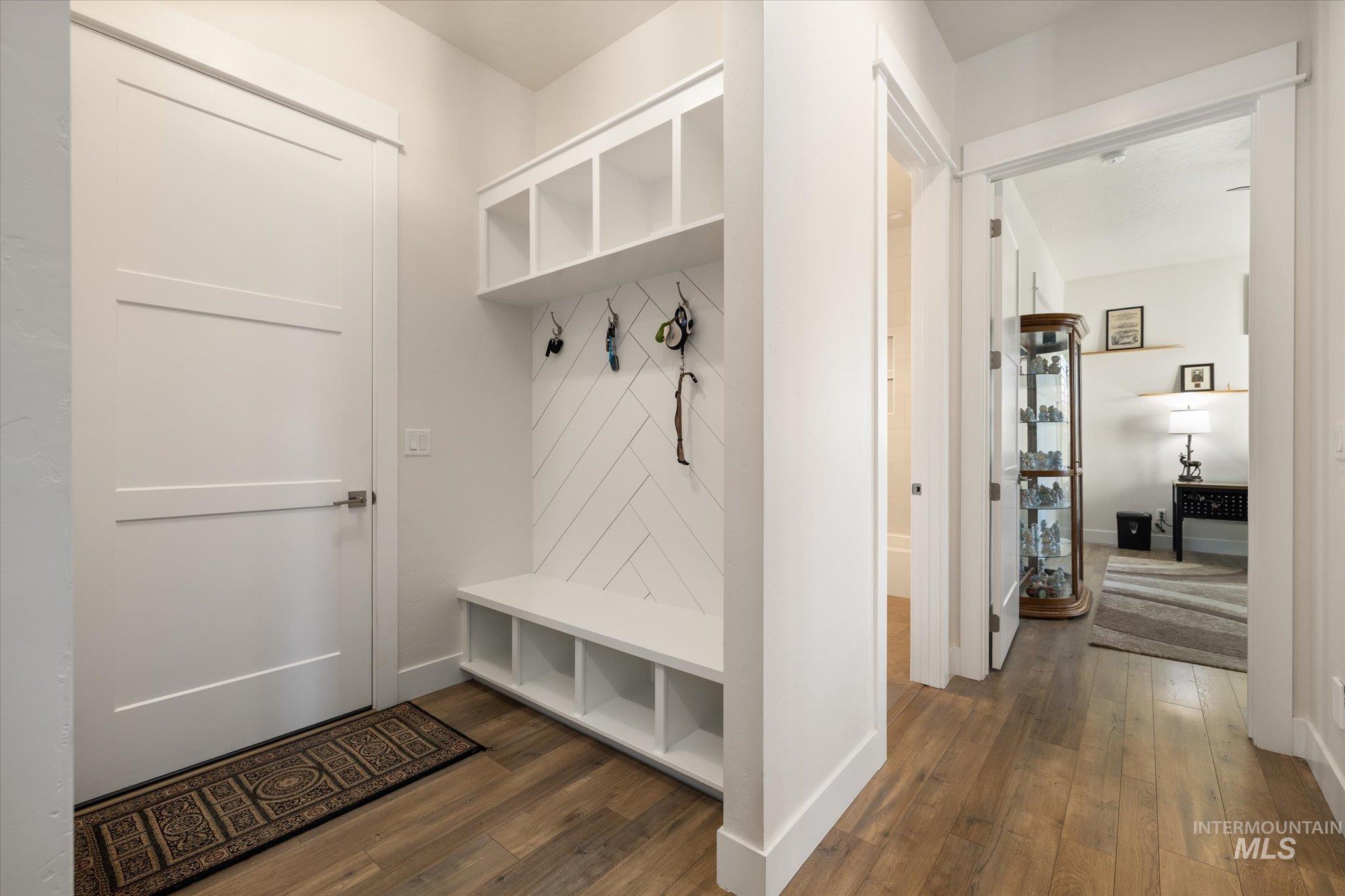 Mudroom with dark wood-type flooring and baseboards