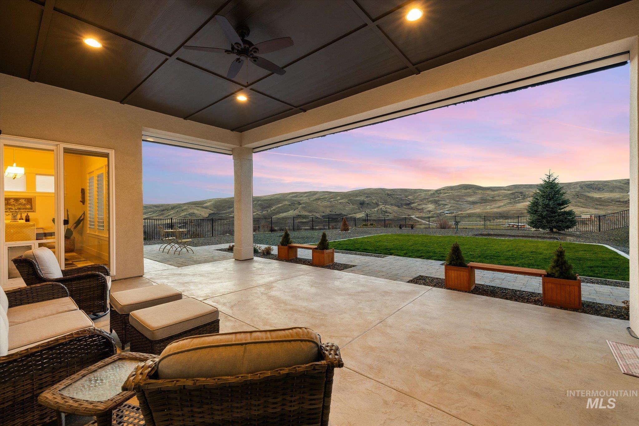 Fenced backyard featuring a patio, ceiling fan, and a mountain view