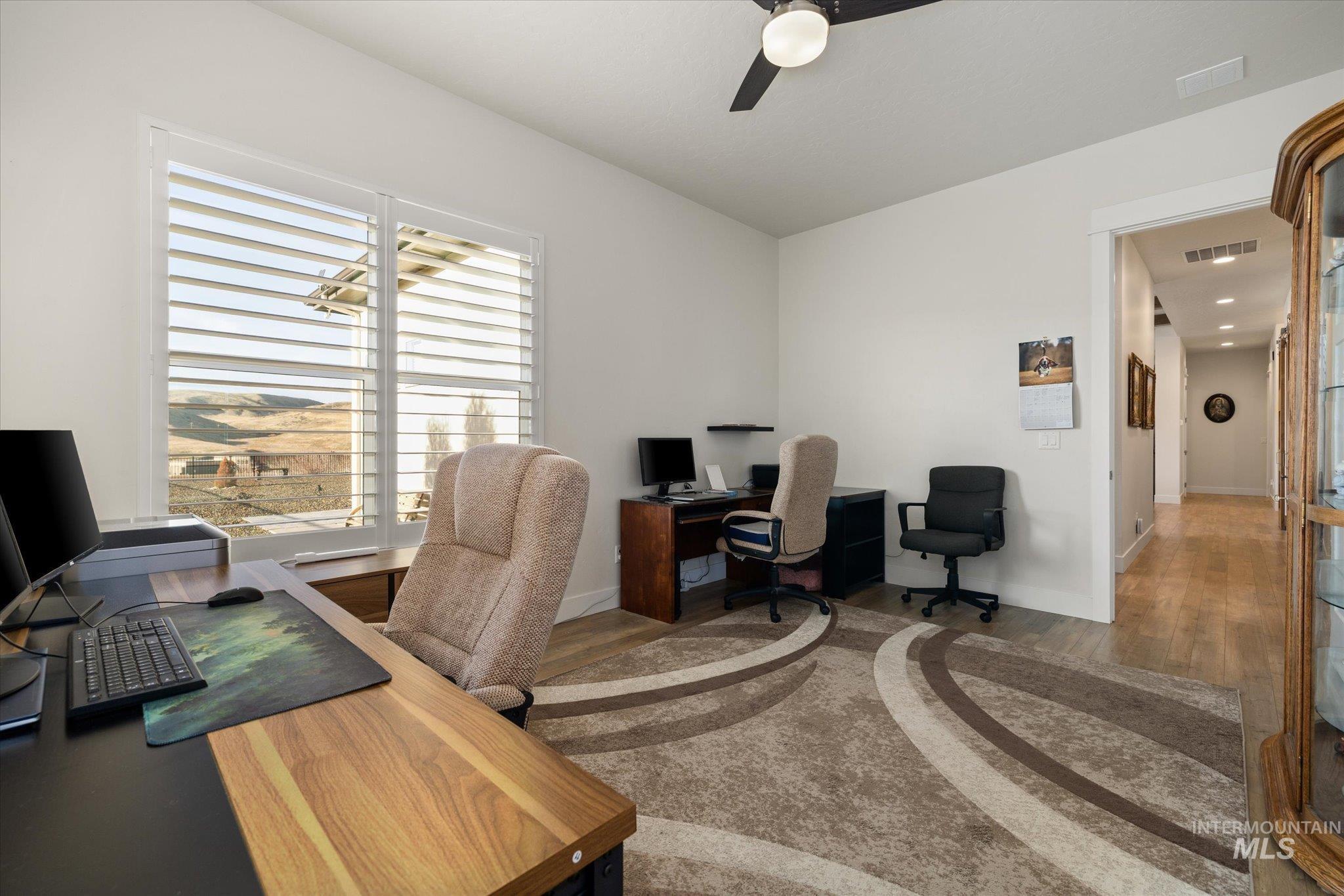 Home office with wood finished floors and ceiling fan