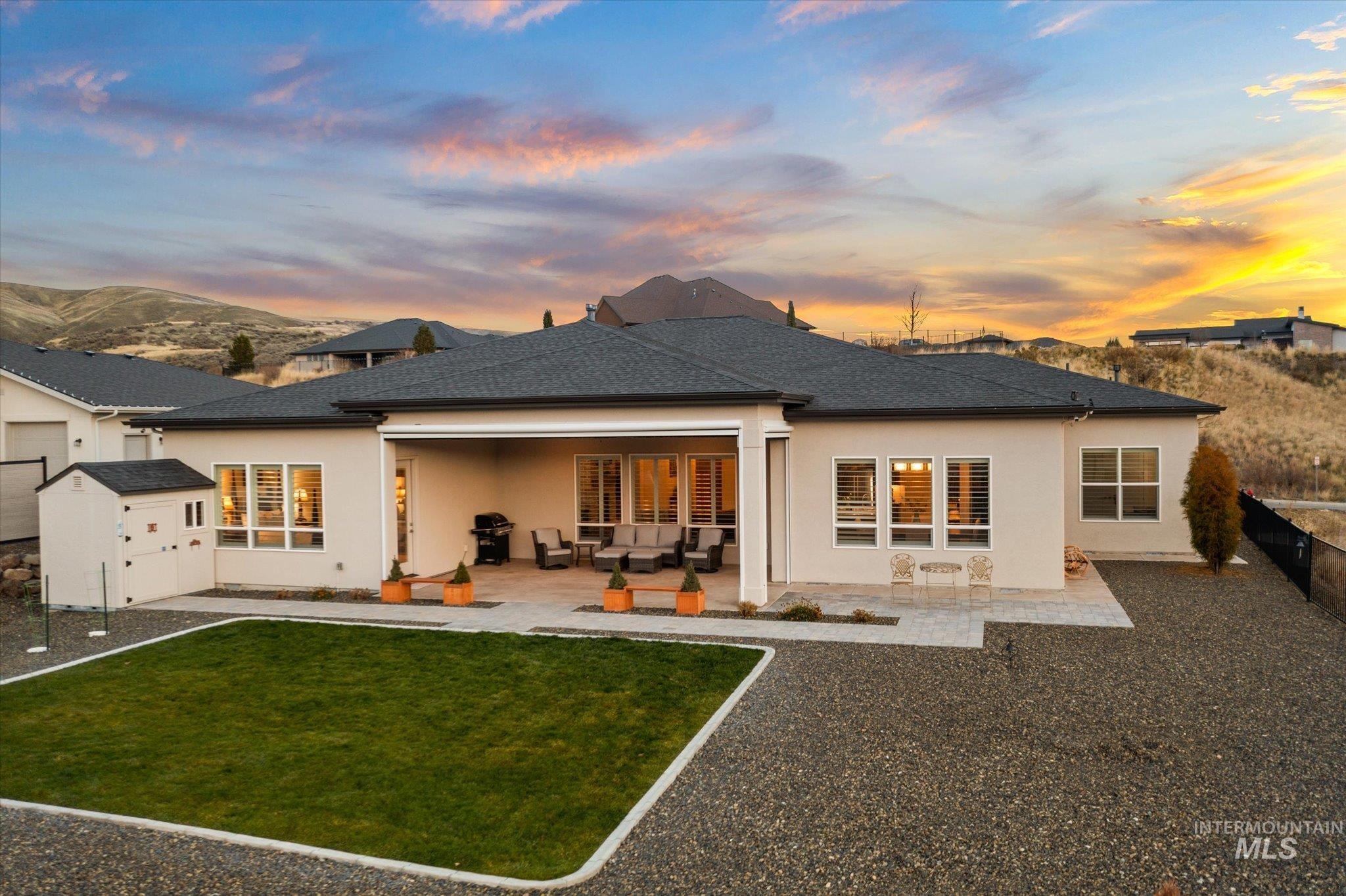 Back of property at dusk featuring a patio, stucco siding, and outdoor lounge area