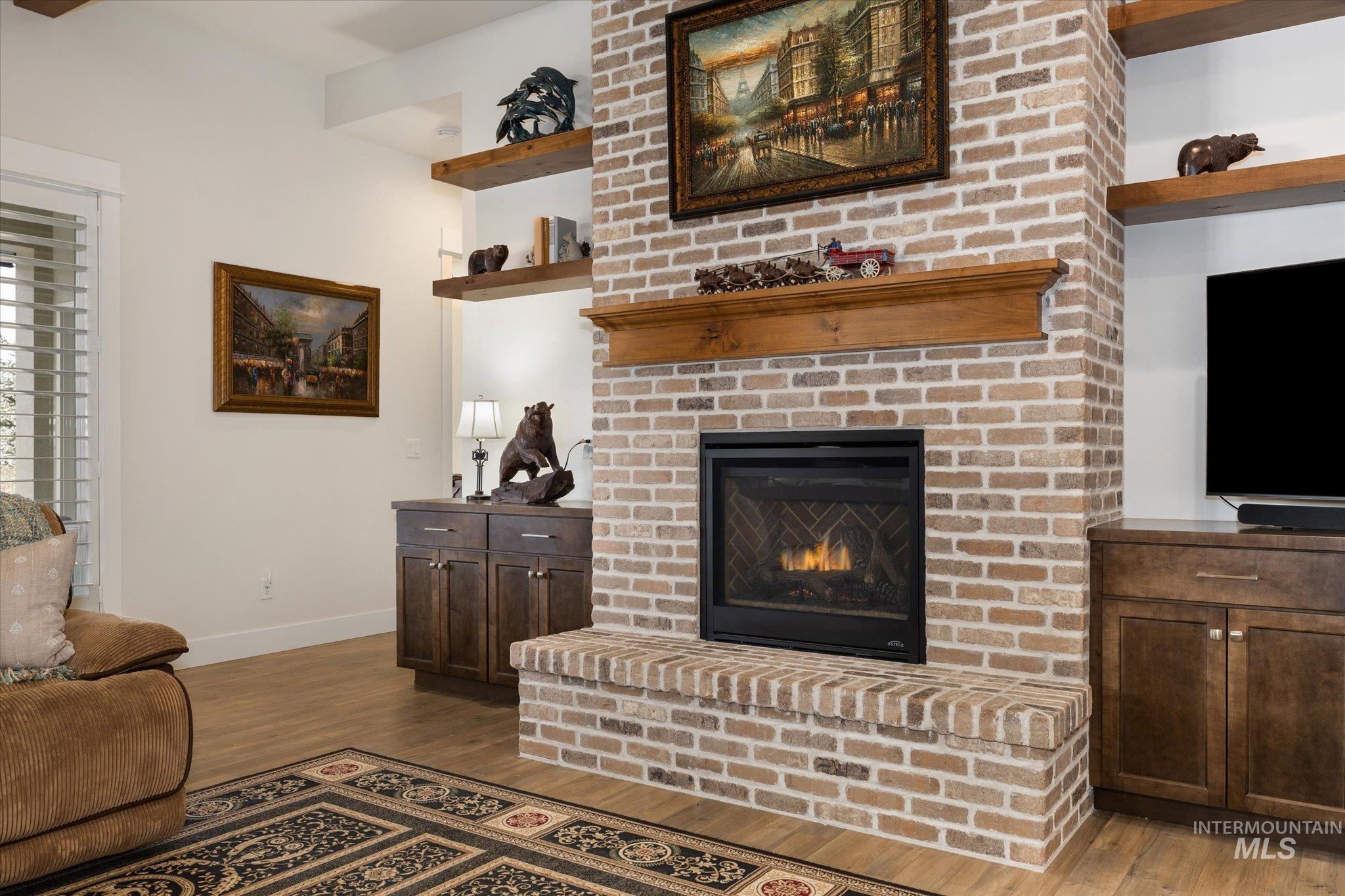 Living area featuring a brick fireplace and light wood finished floors
