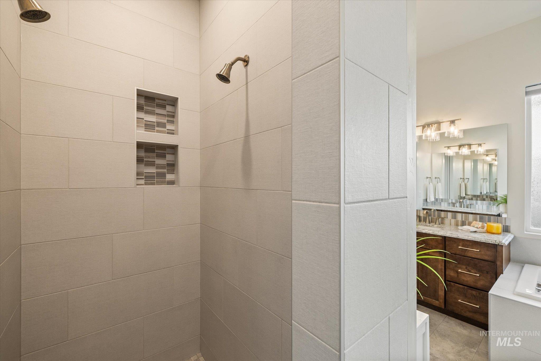 Bathroom featuring vanity and a tile shower