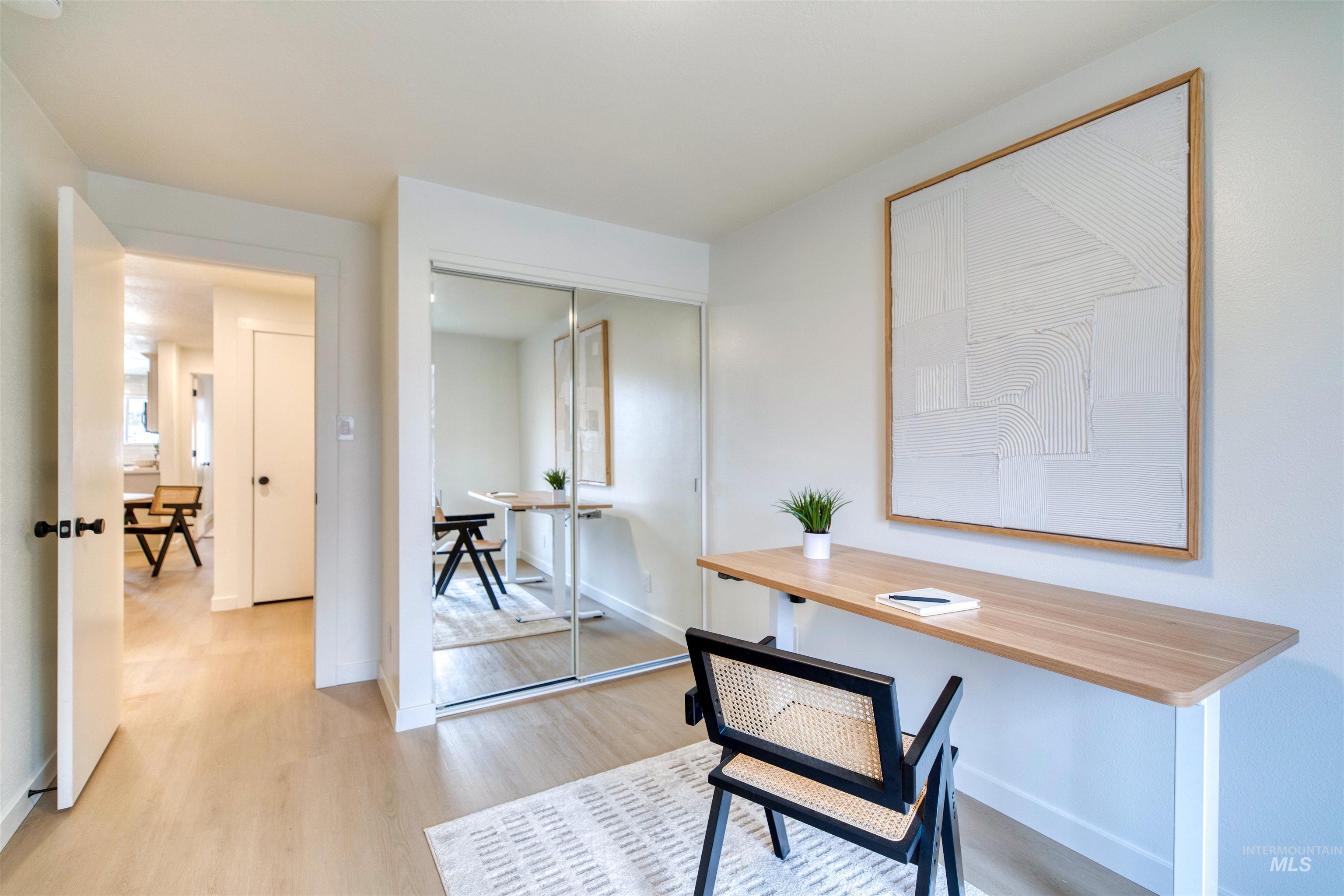 Office space with light wood-style flooring and baseboards