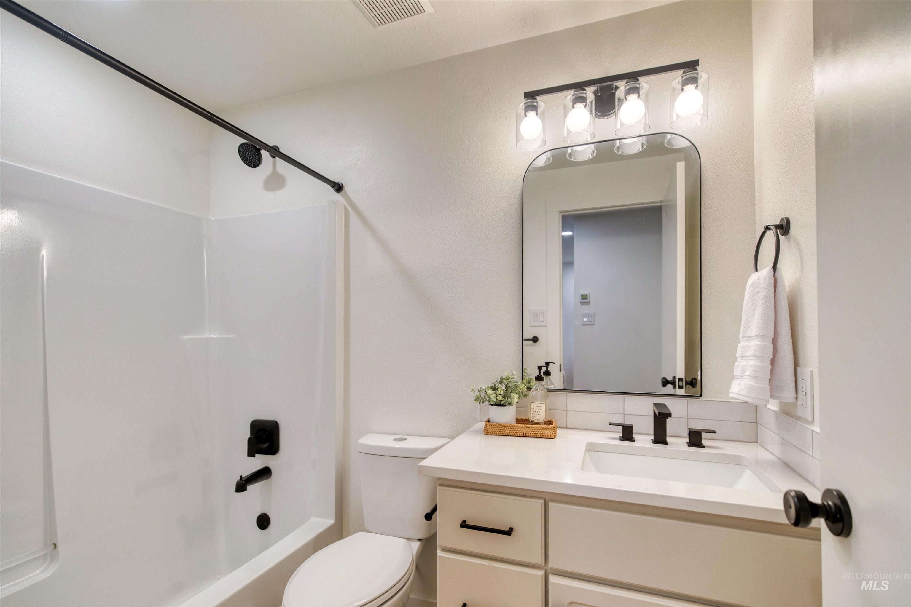 Bathroom featuring shower / bath combo with shower curtain and vanity