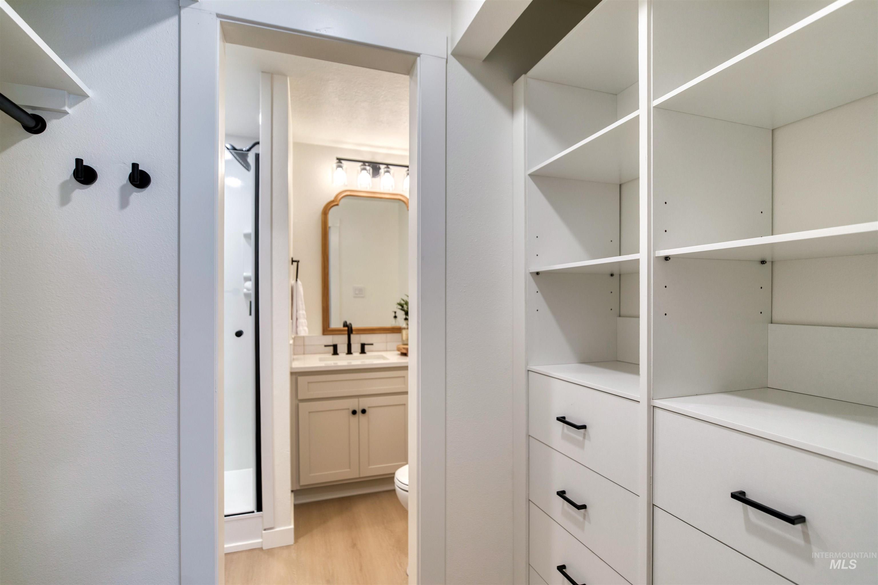 Walk in closet with light wood-style floors and a sink