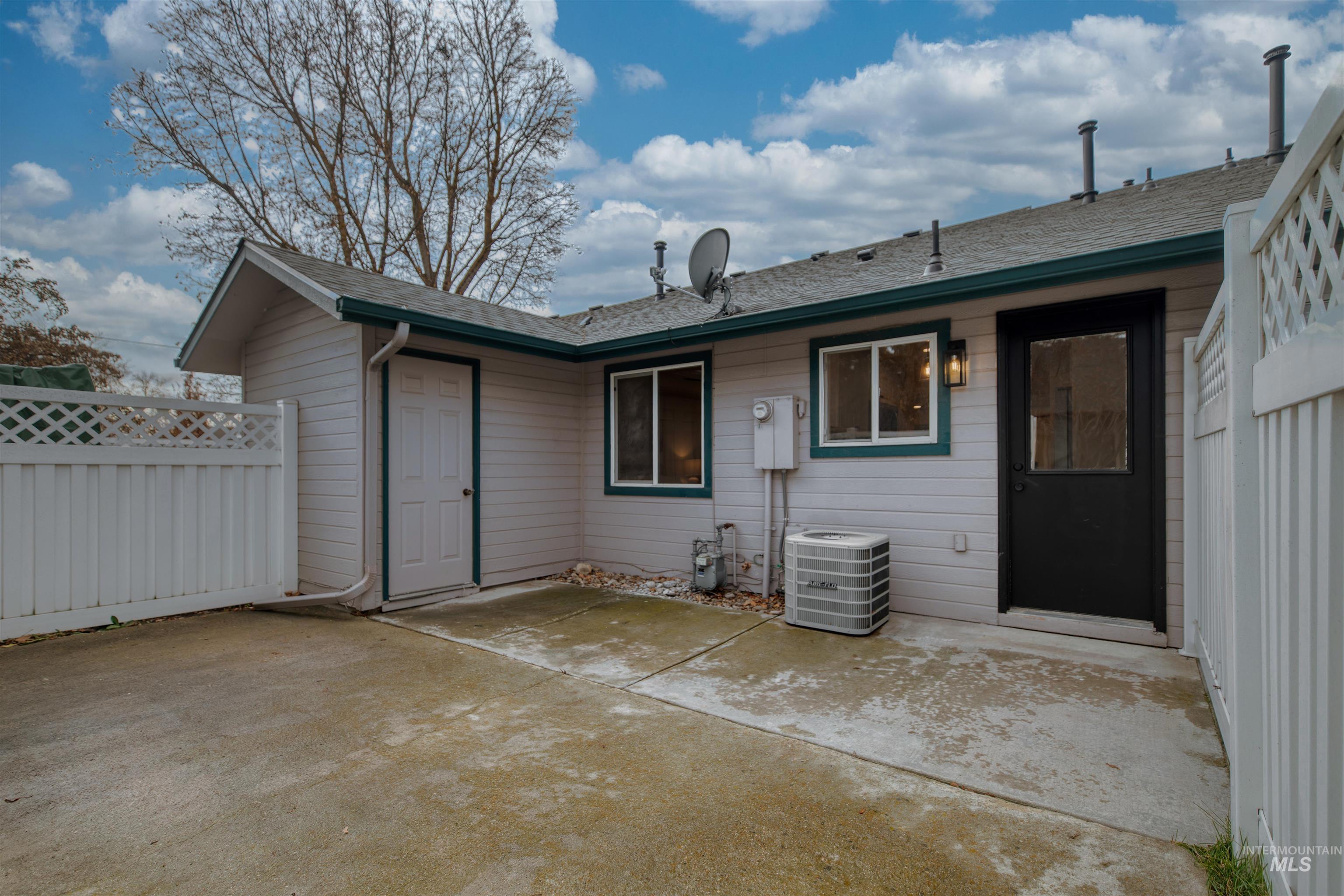 Rear view of house featuring a patio area and a shingled roof