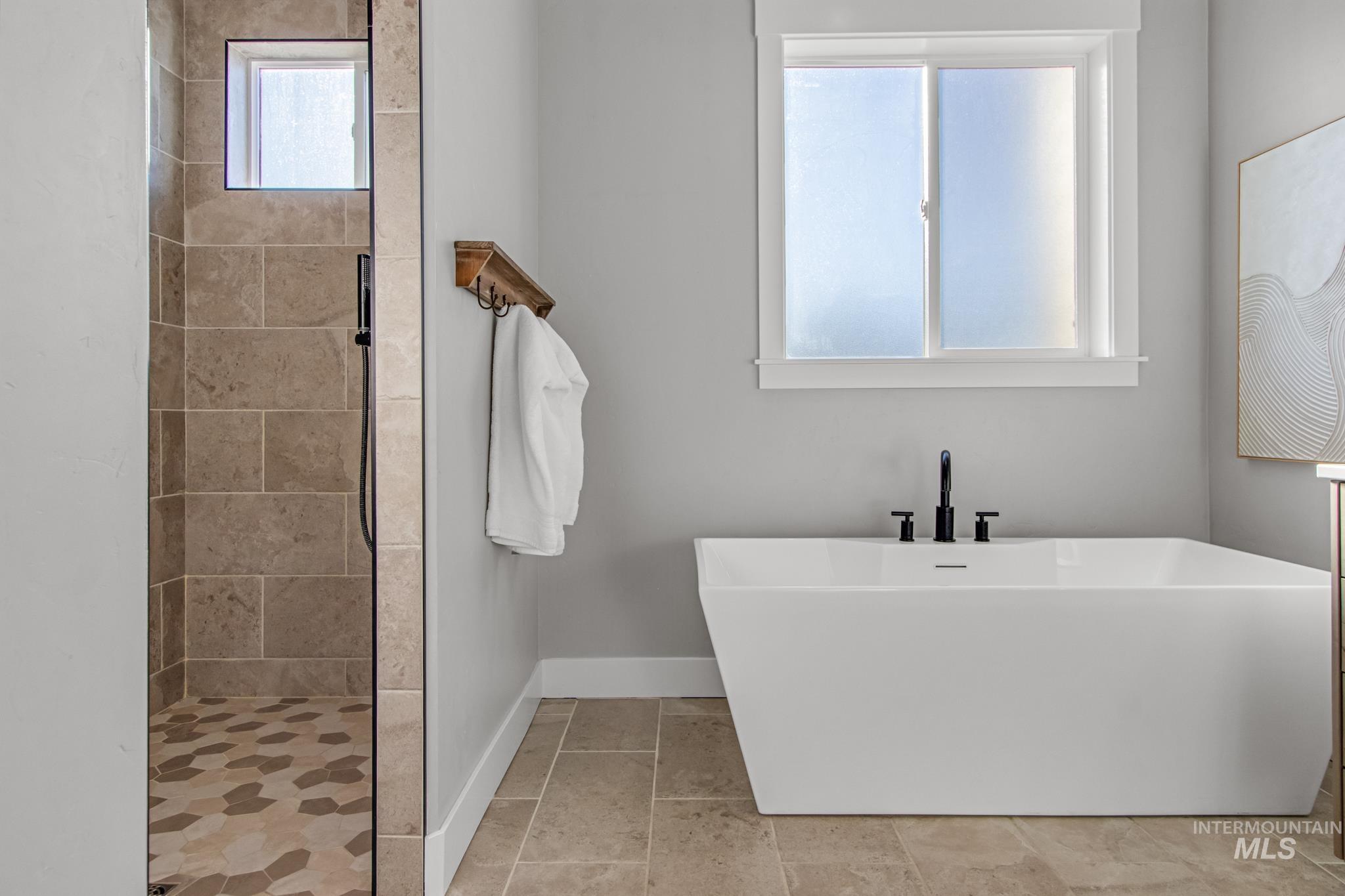 Full bath featuring a stall shower and a freestanding tub