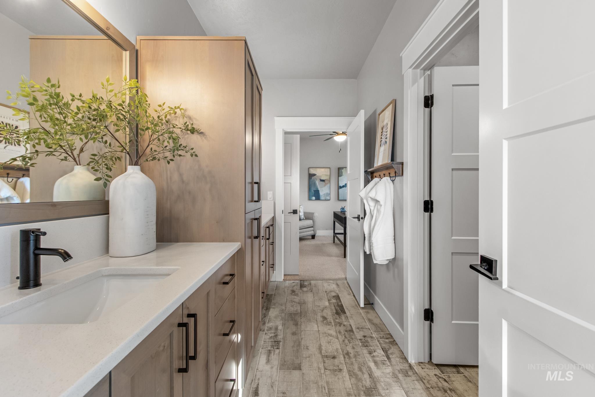 Bathroom with vanity, light wood-style flooring, and a ceiling fan