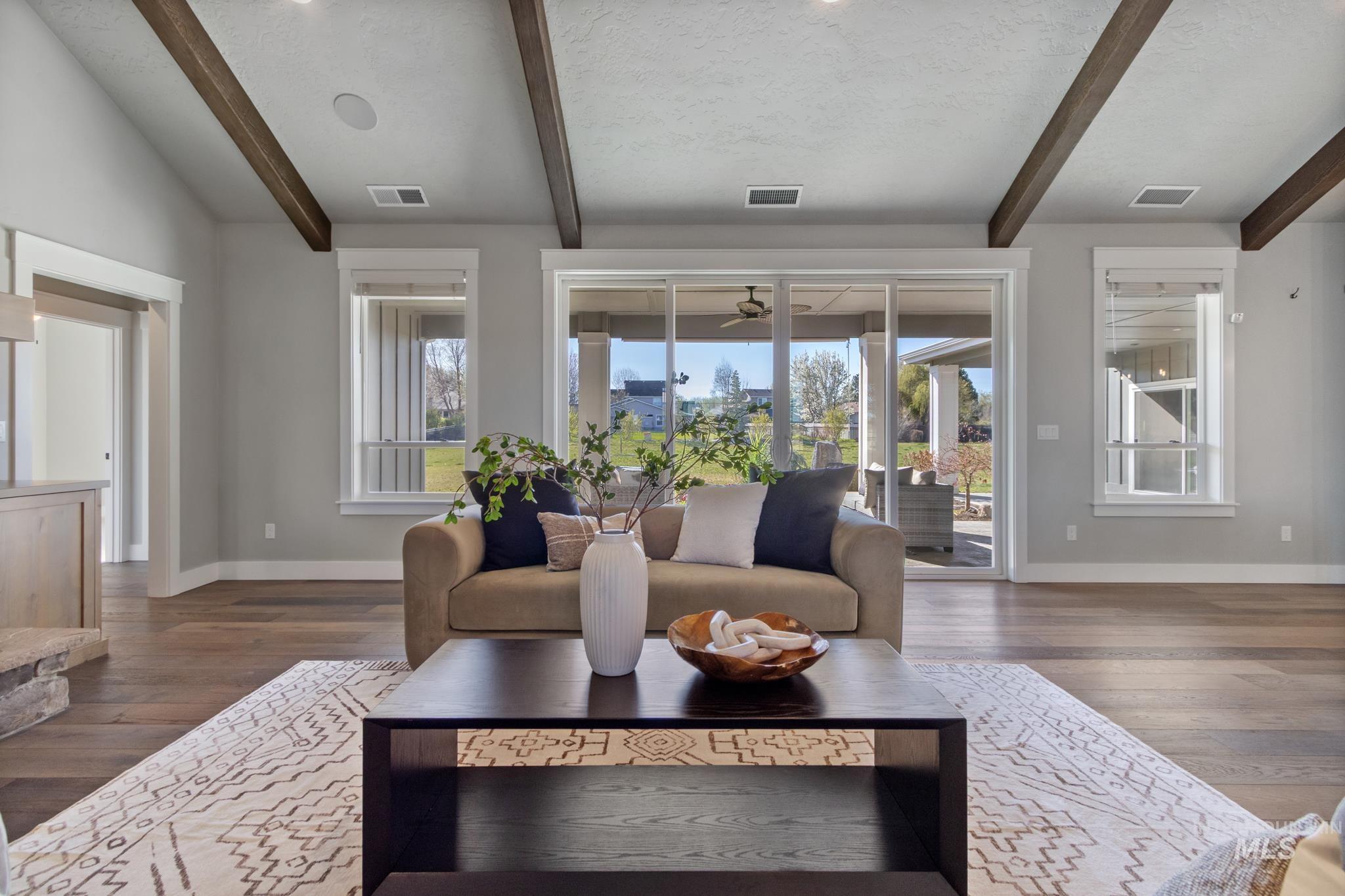 Living area with beam ceiling and dark wood-style floors