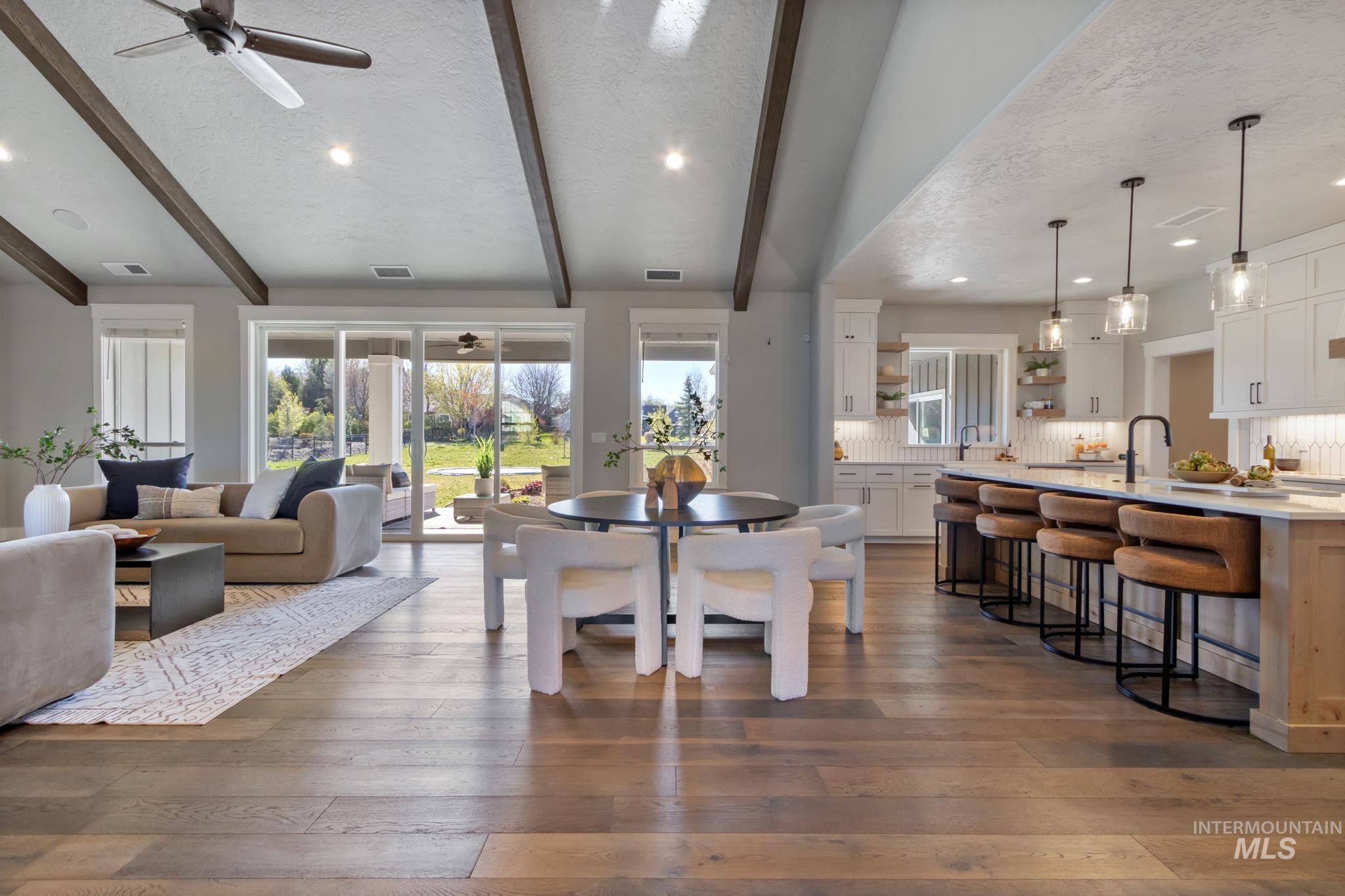 Dining area with beamed ceiling, a textured ceiling, dark wood-type flooring, recessed lighting, and ceiling fan