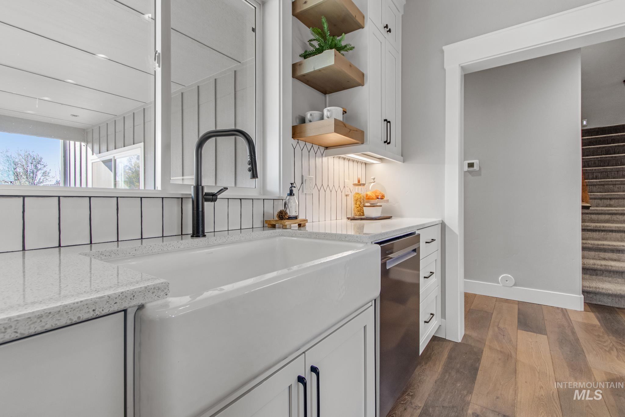 Kitchen featuring open shelves, light stone counters, dark wood finished floors, and white cabinets