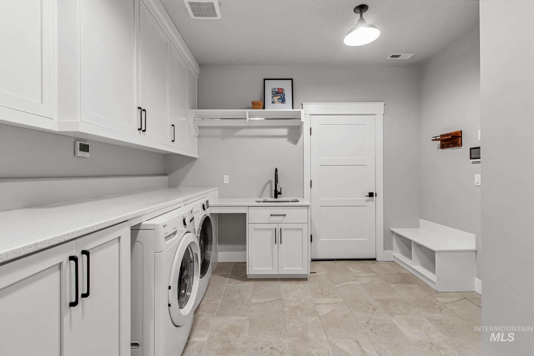 Laundry room featuring washer and clothes dryer and cabinet space