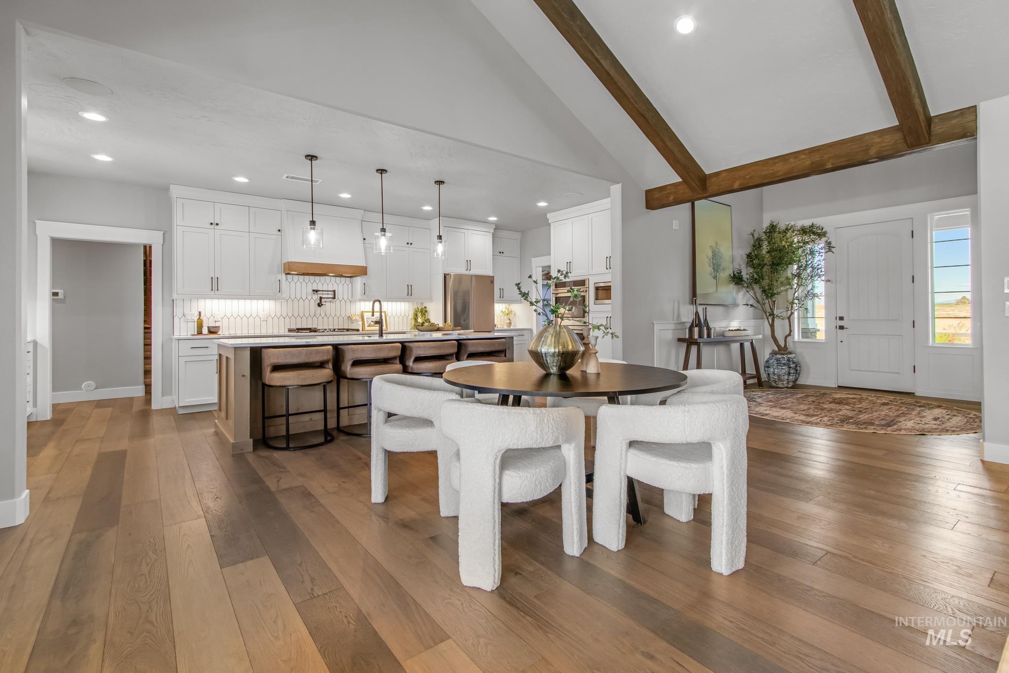 Dining space featuring dark wood finished floors, lofted ceiling, and recessed lighting