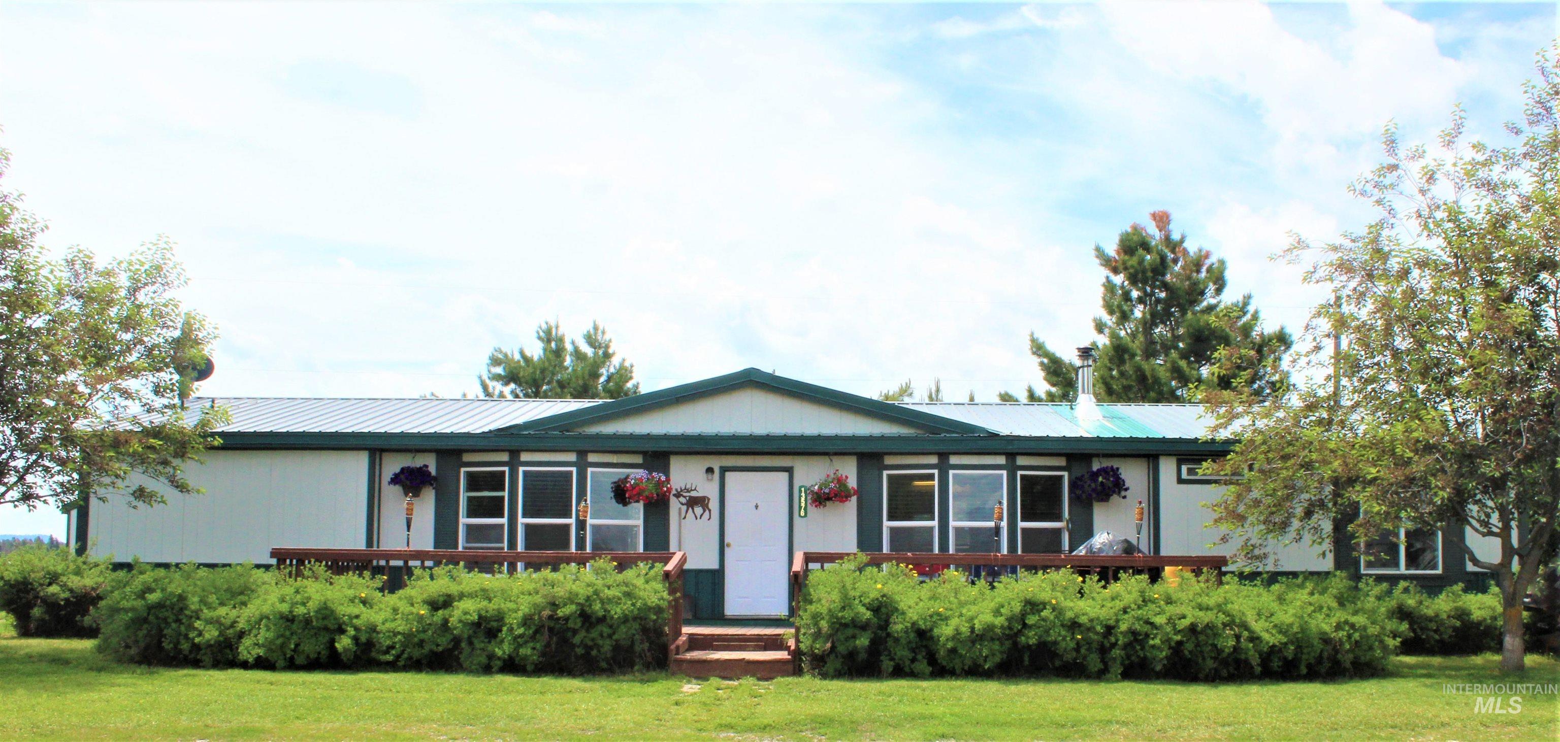 Ranch-style house featuring a metal roof and a front lawn