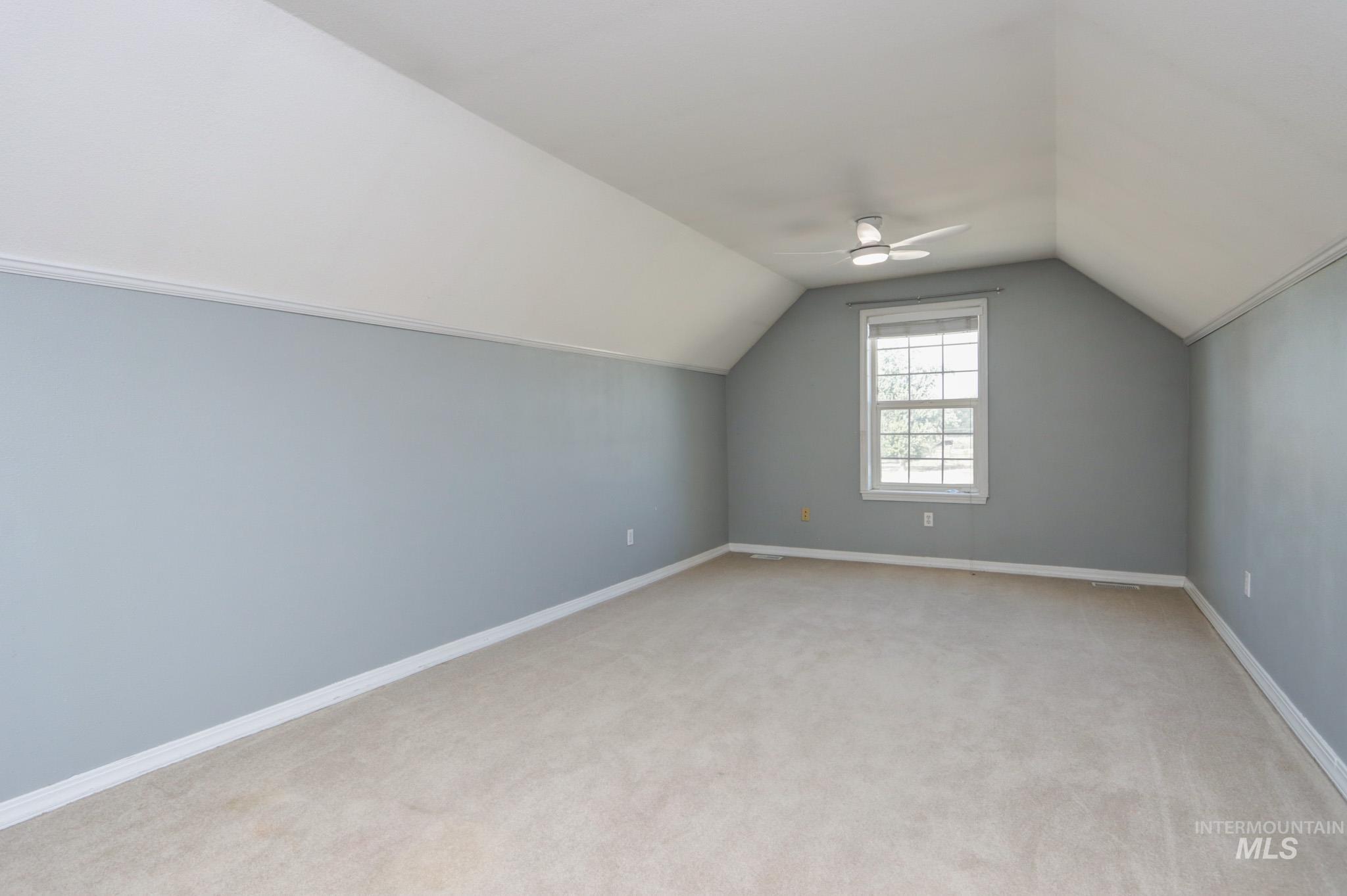Bonus room featuring vaulted ceiling, light colored carpet, and ceiling fan
