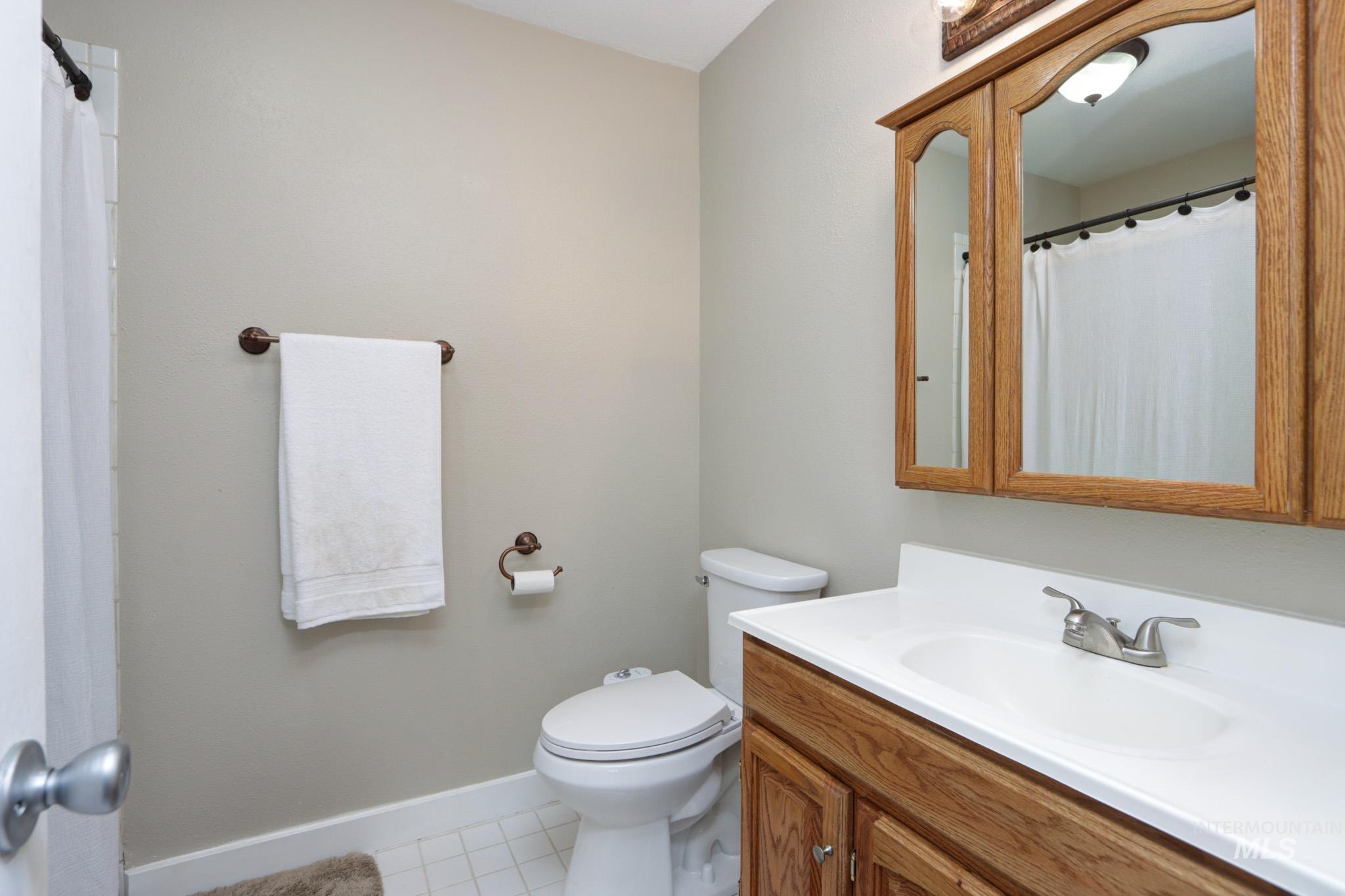 Full bath with vanity, light tile patterned flooring, and a shower with shower curtain