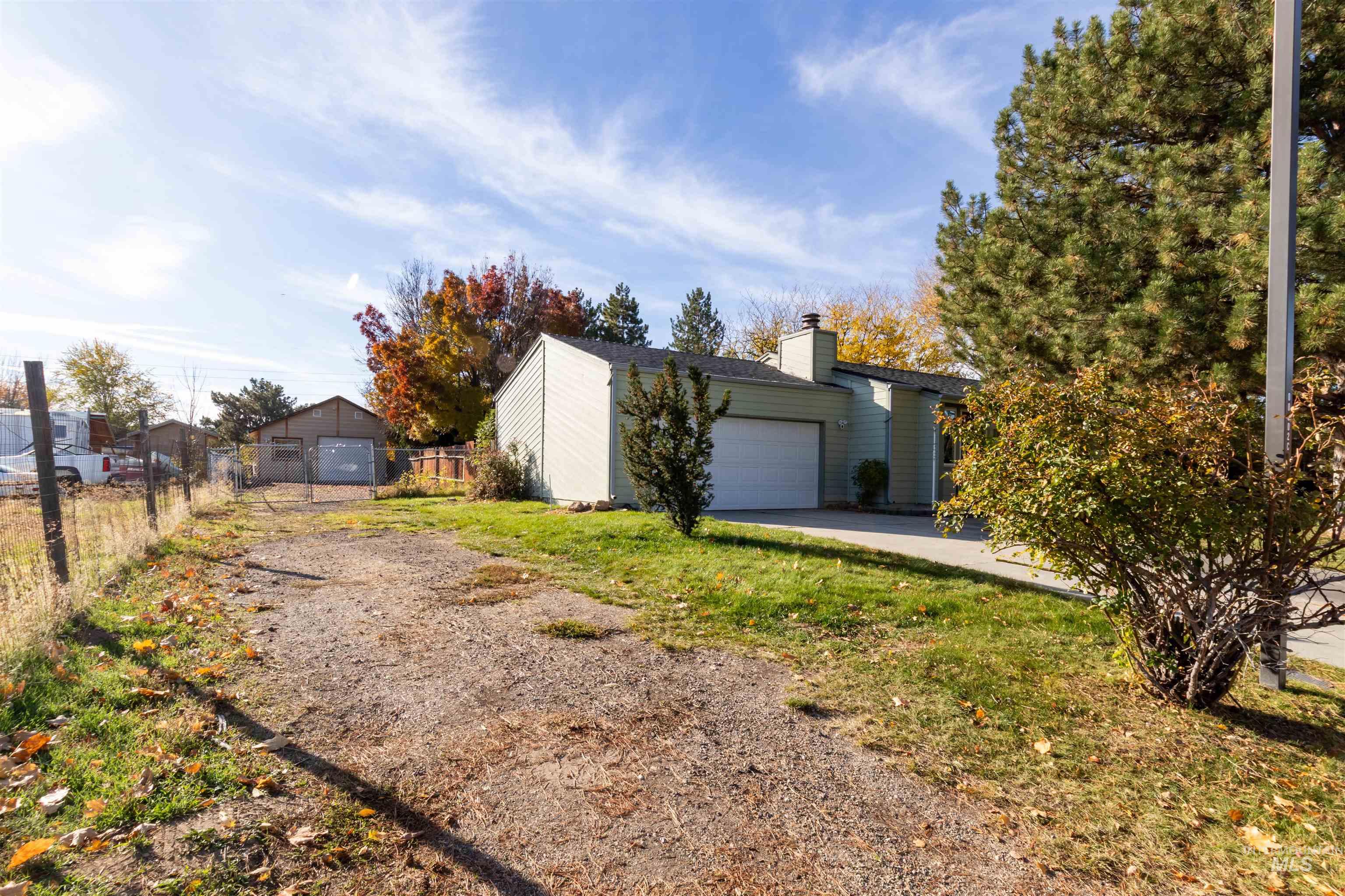 View of front of property with a garage, a chimney, and driveway