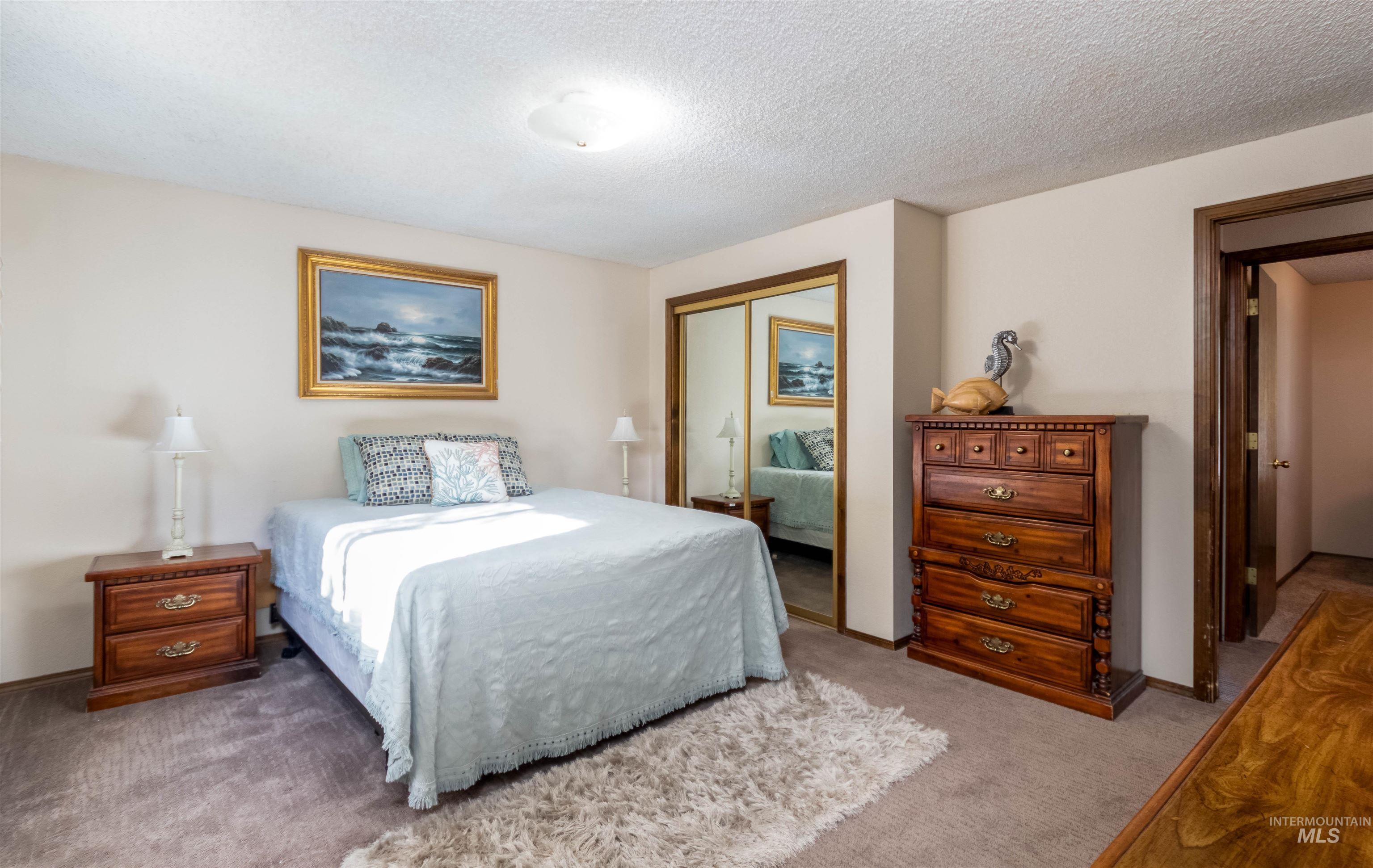 Bedroom featuring carpet flooring, a textured ceiling, and a closet