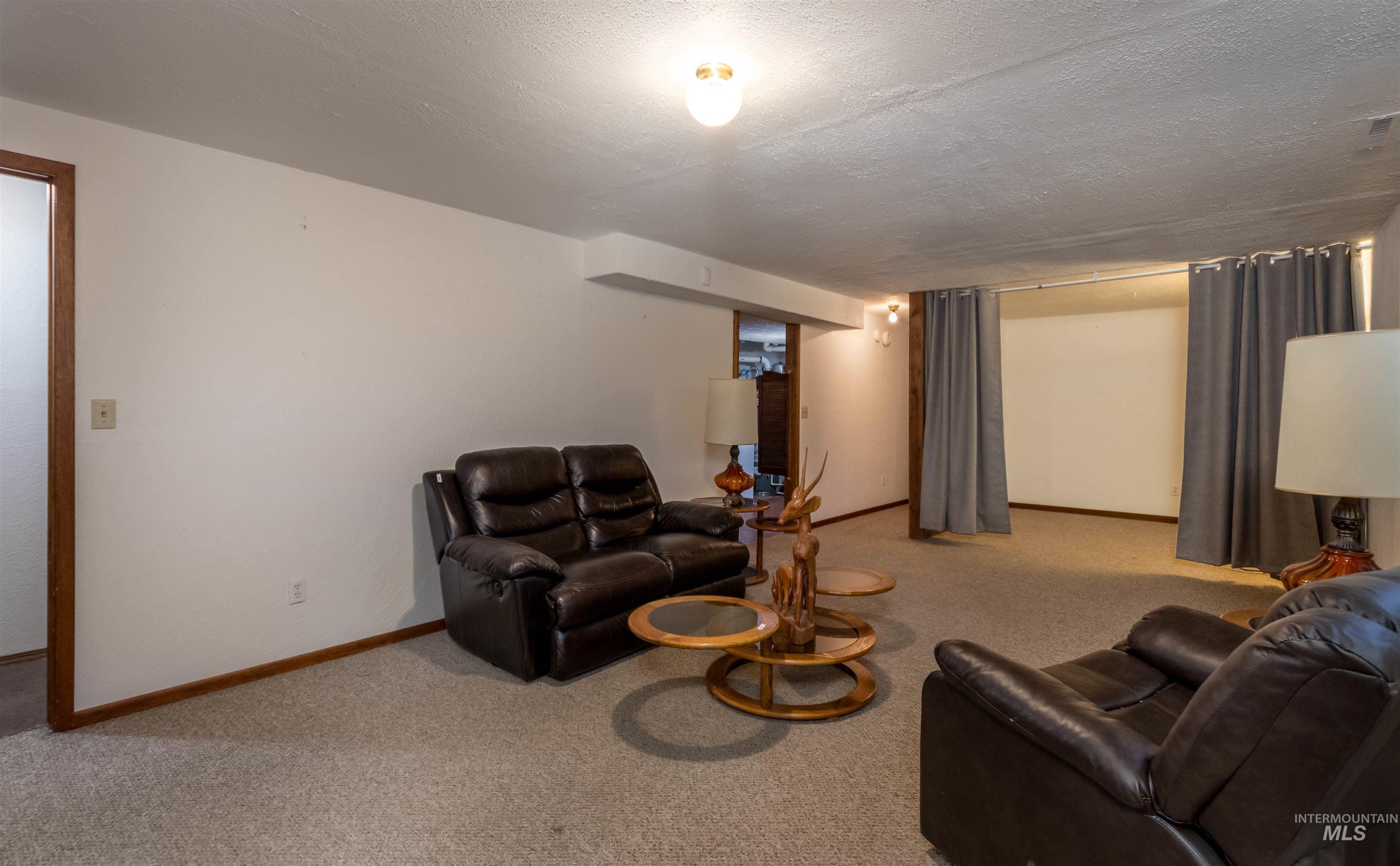 Living area featuring light carpet and a textured ceiling
