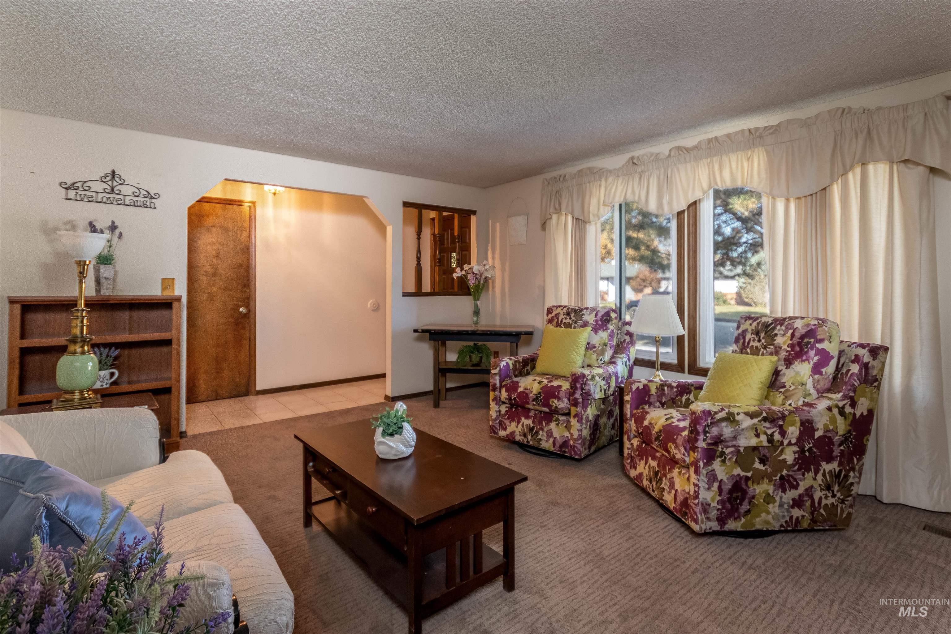 Living room with carpet flooring and a textured ceiling
