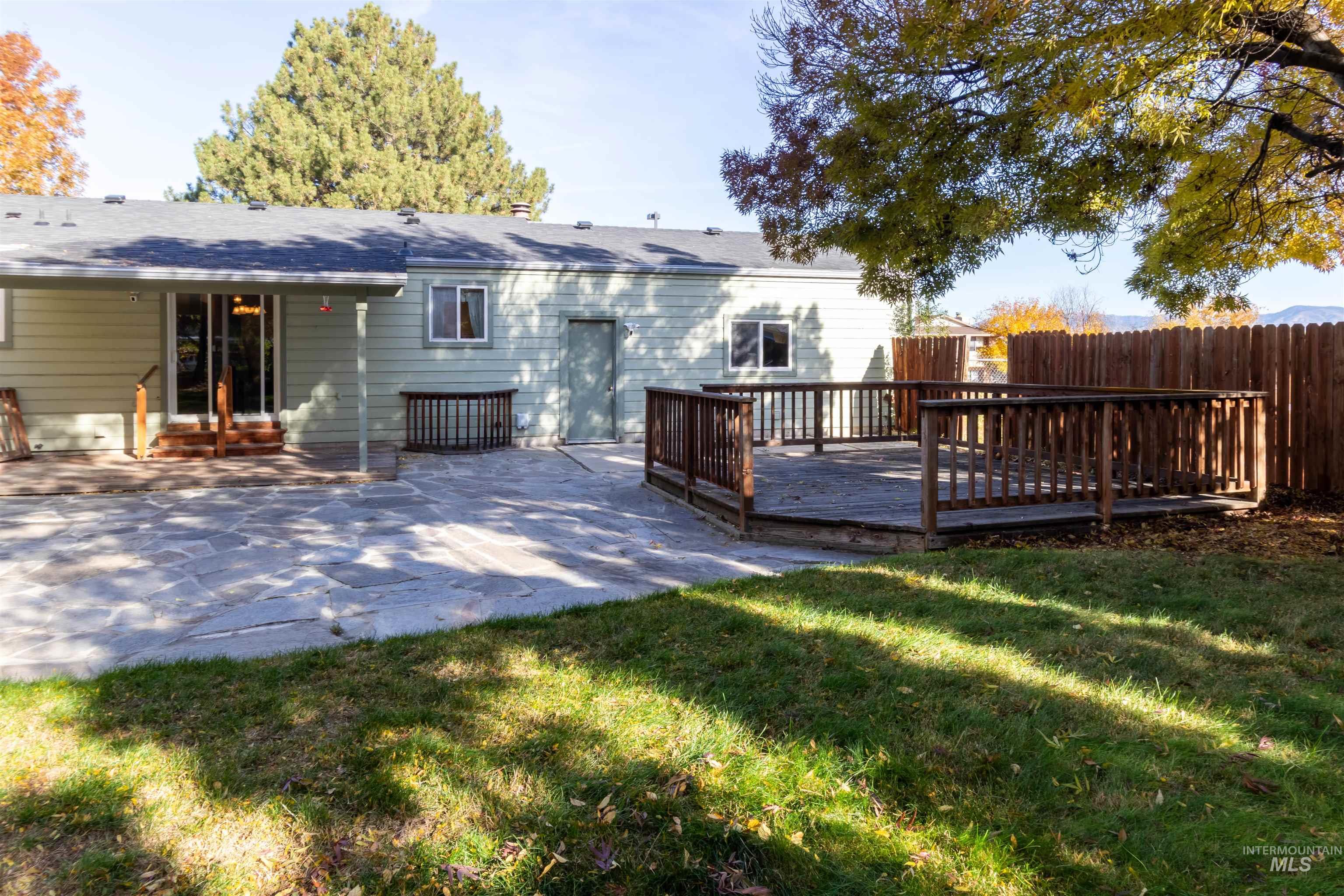 Back of property with a deck and a patio