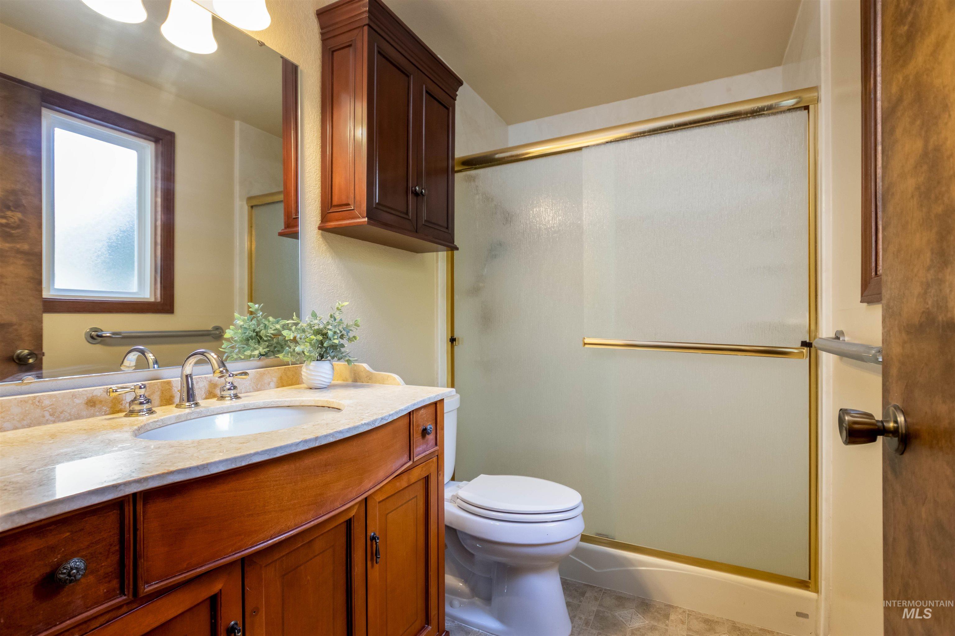 Full bath with vanity, a shower stall, and light tile patterned floors