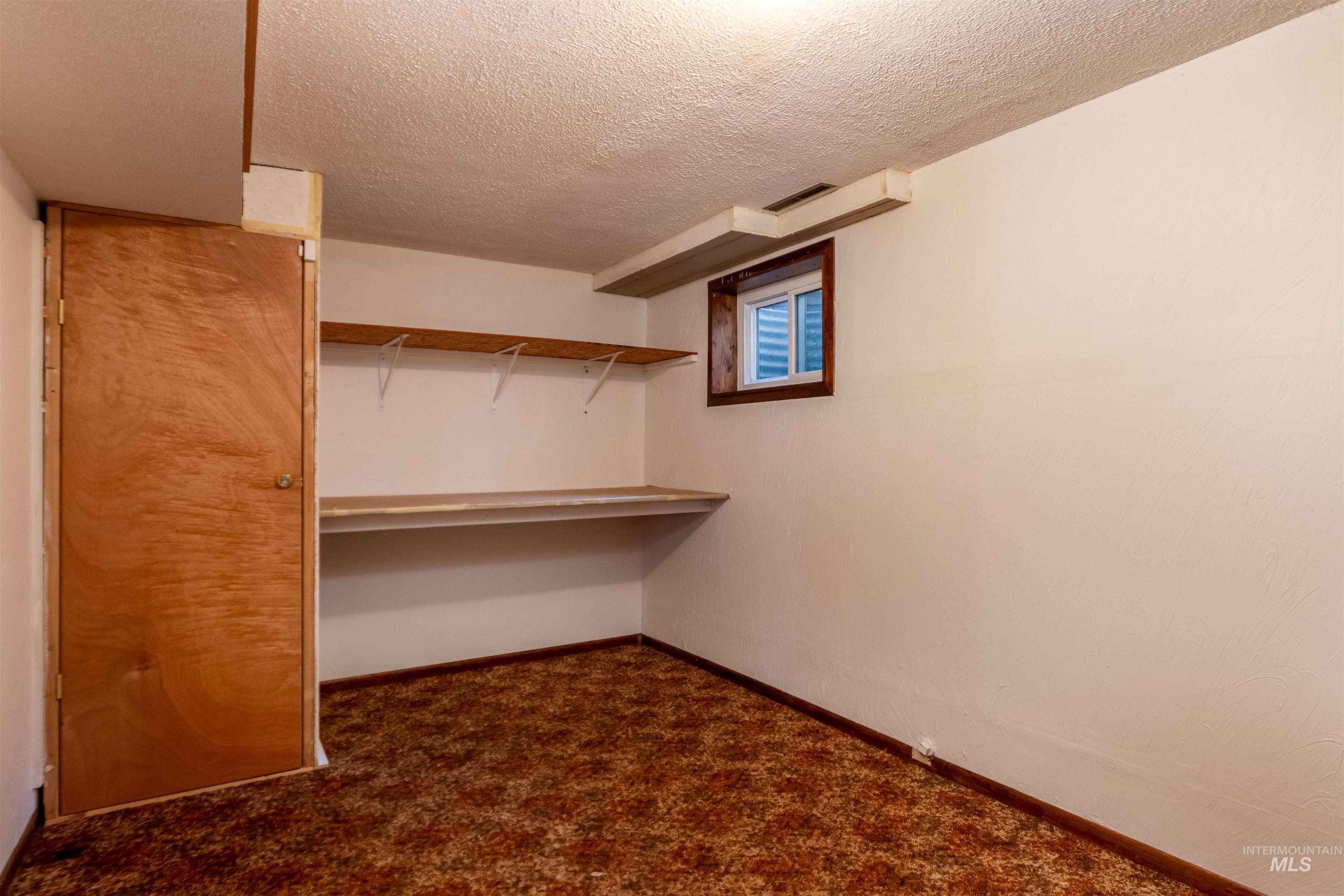 Spacious closet with dark carpet
