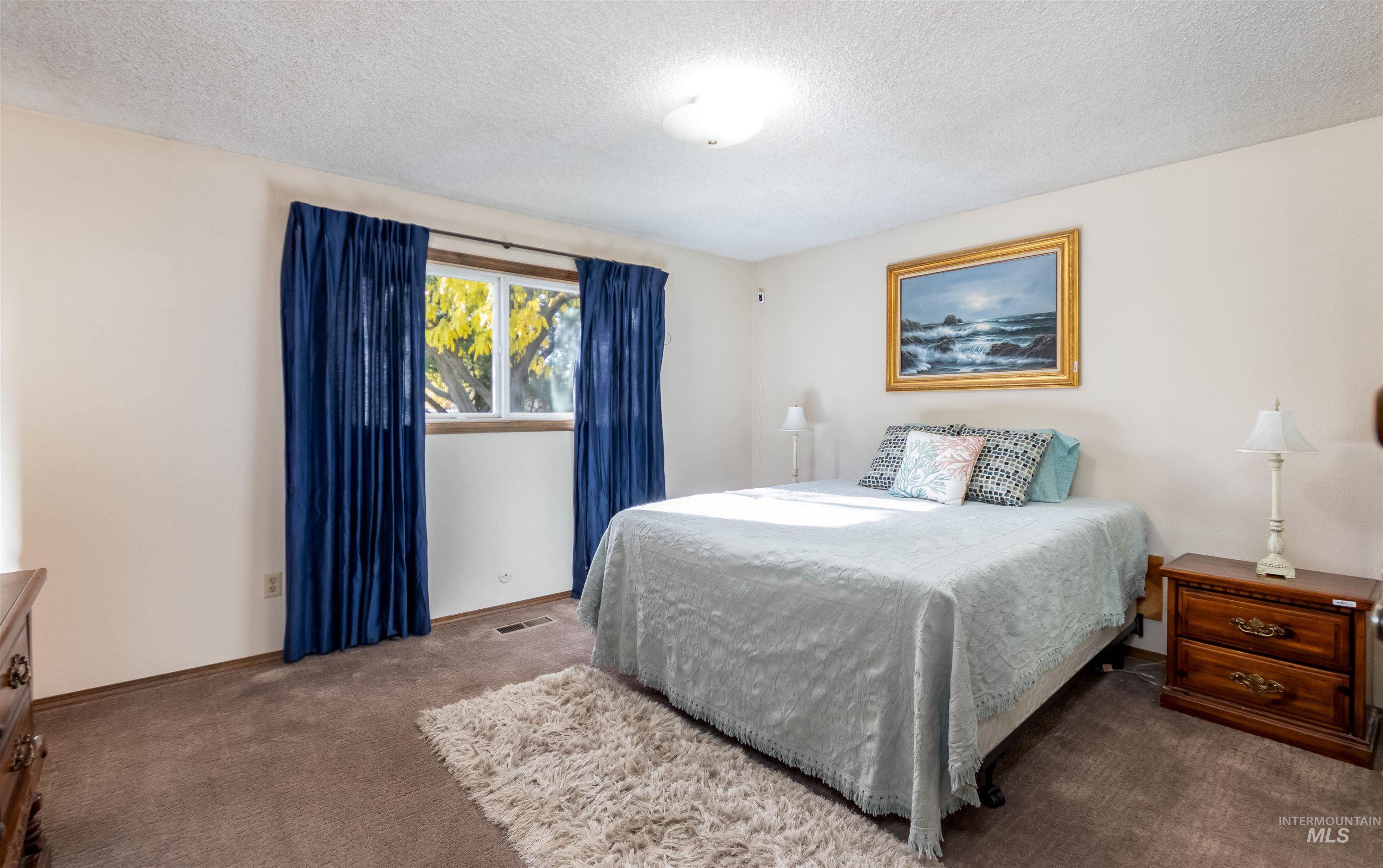 Carpeted bedroom featuring a textured ceiling