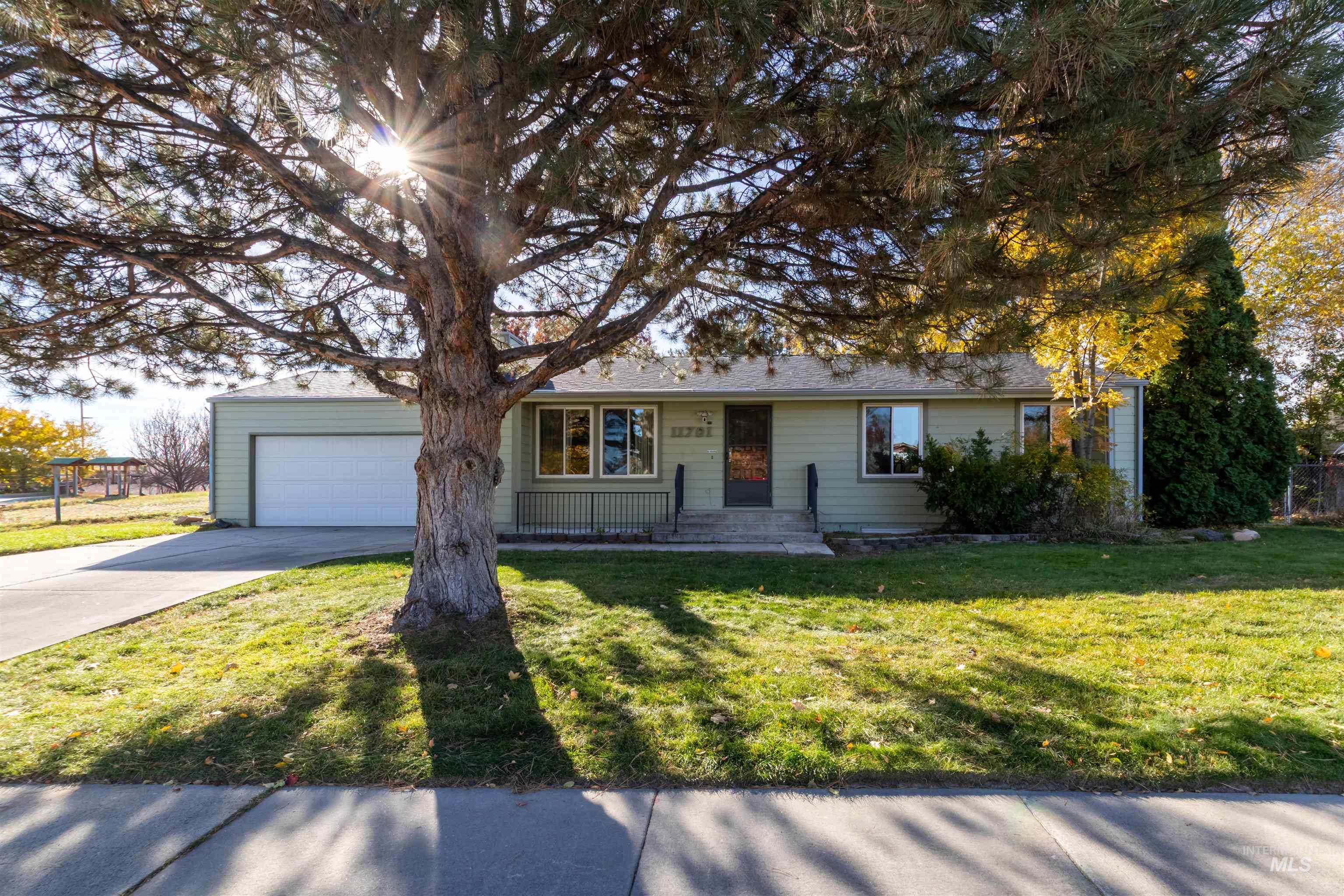 Single story home featuring a front yard, concrete driveway, and an attached garage