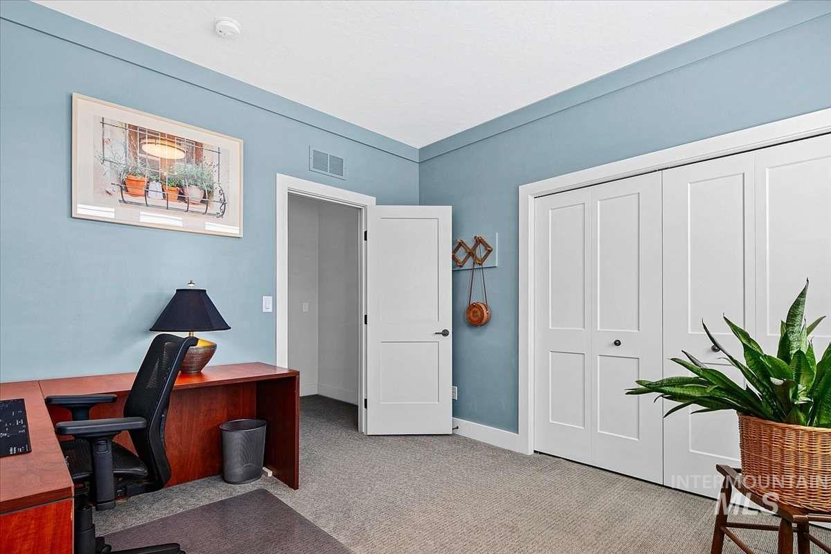 Office with light colored carpet and baseboards