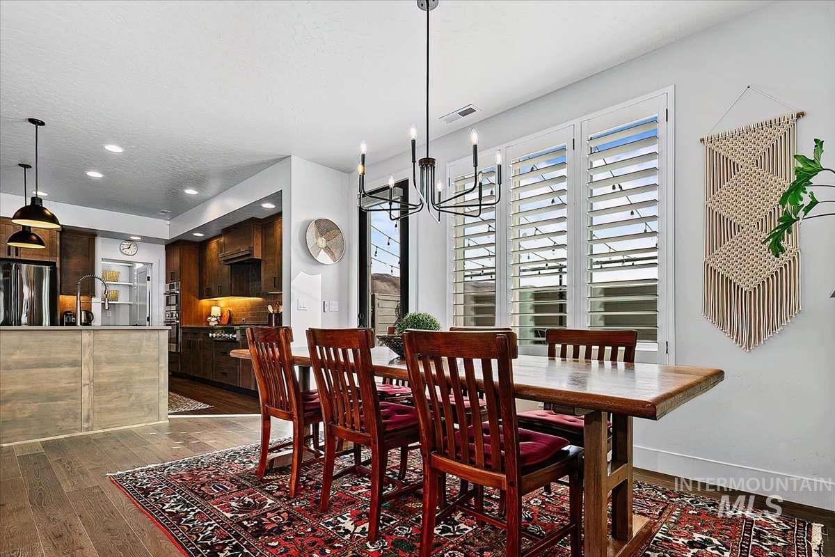 Dining space with dark wood-type flooring and a chandelier