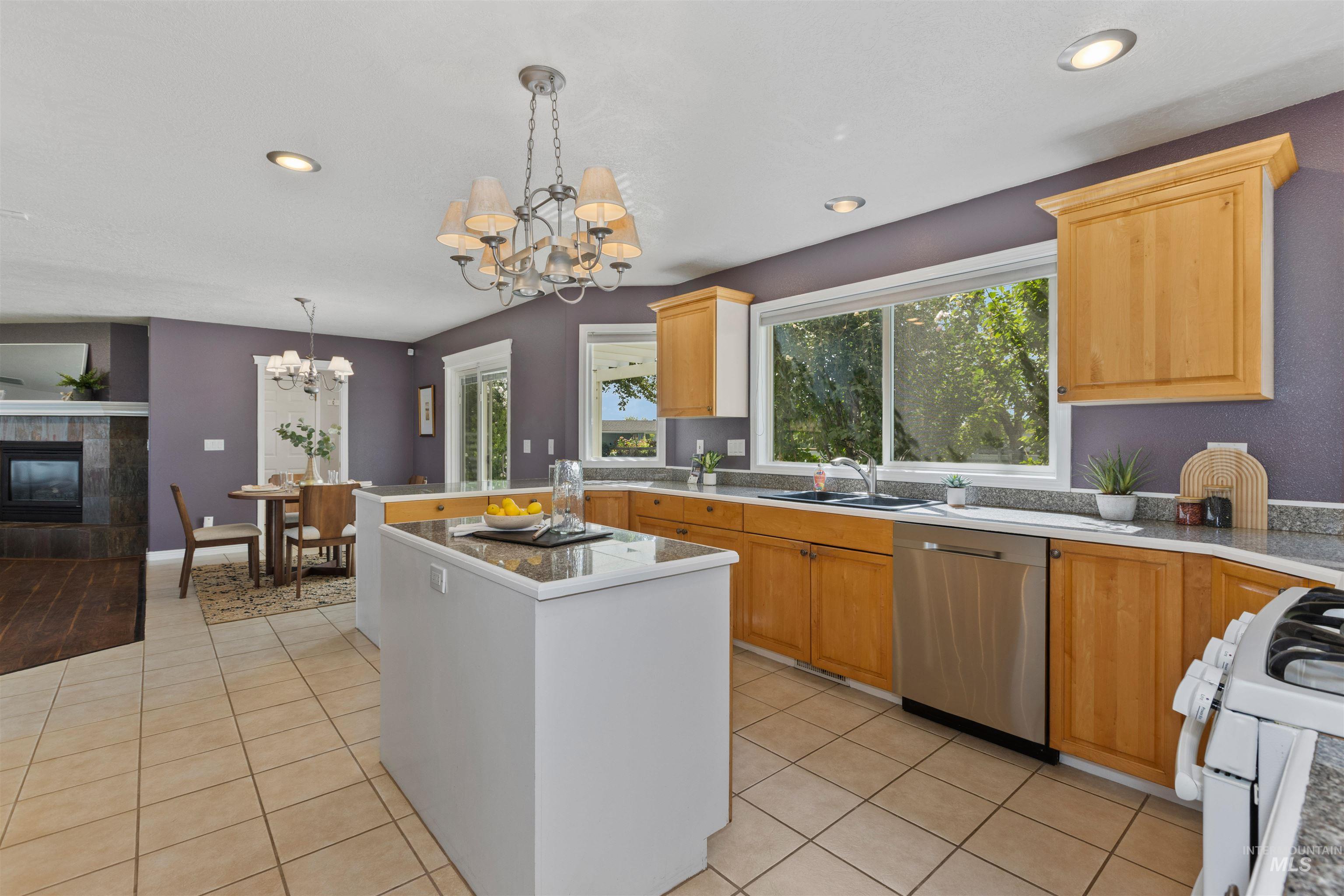 Kitchen featuring a center island, gas range gas stove, pendant lighting, light countertops, and stainless steel dishwasher
