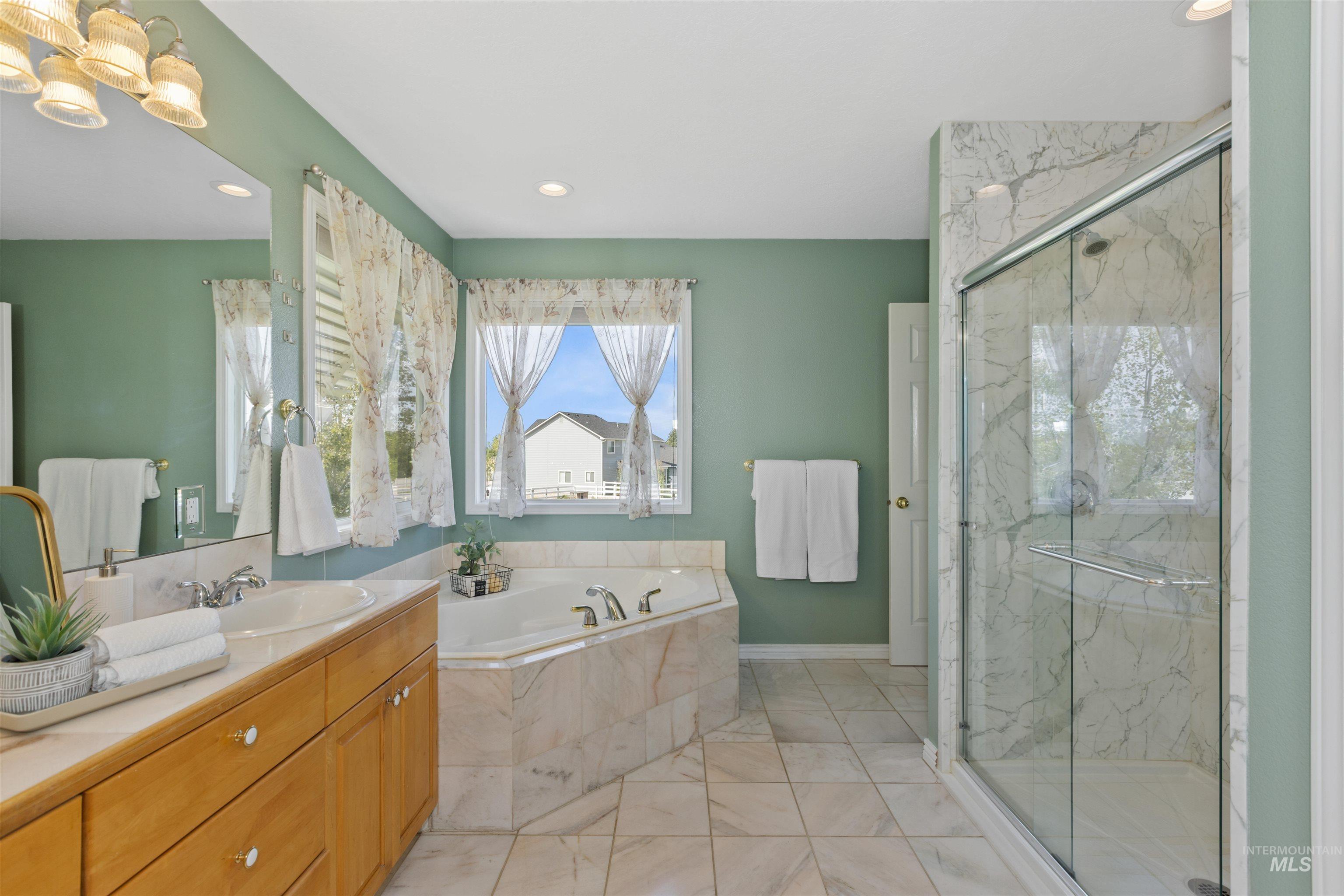 Bathroom with a garden tub, a marble finish shower, vanity, recessed lighting, and light marble finish floors