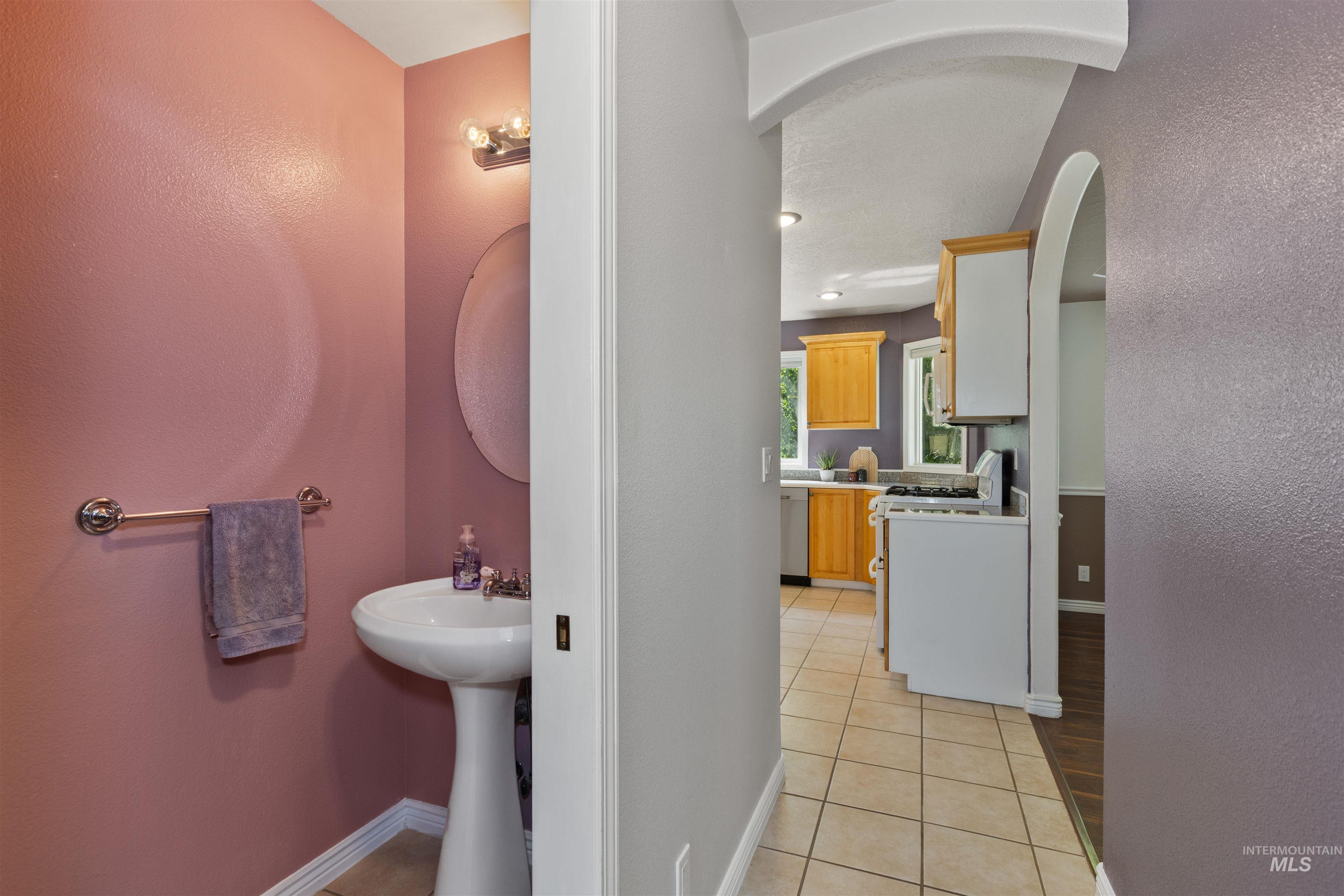Bathroom with a textured wall and light tile patterned floors