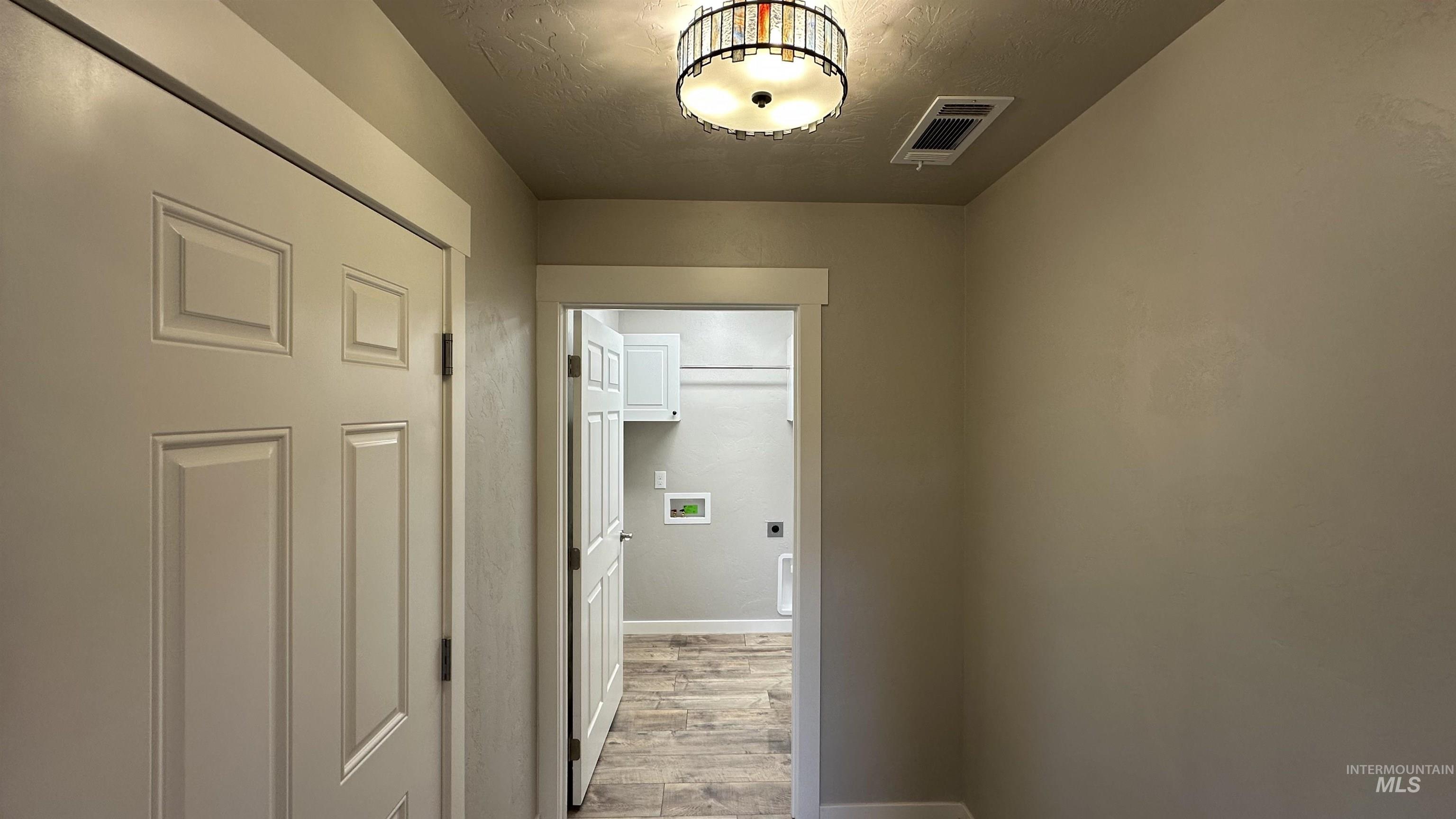 Corridor featuring baseboards and light wood-style flooring