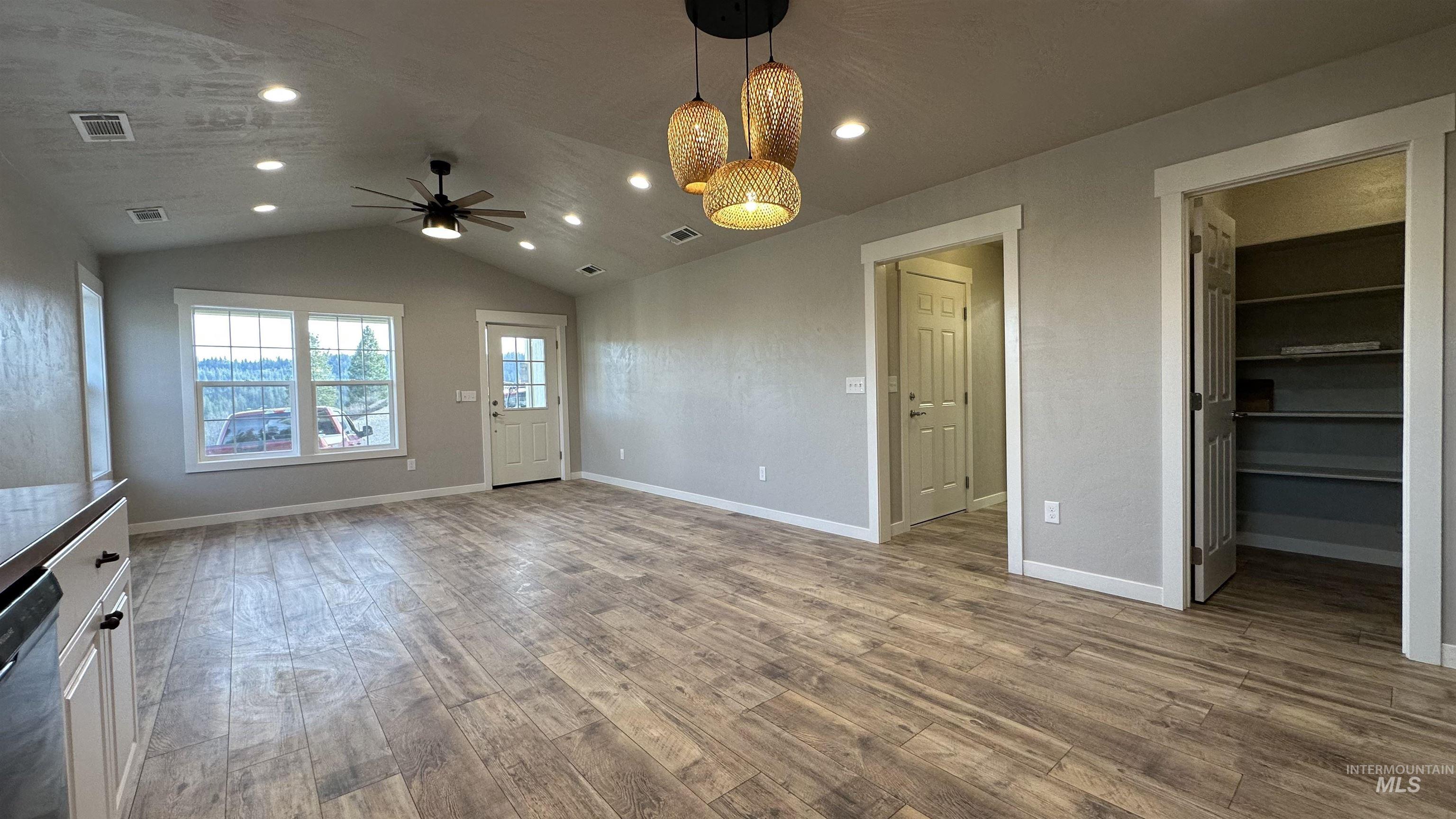 Unfurnished living room featuring vaulted ceiling, light wood-style floors, recessed lighting, and ceiling fan