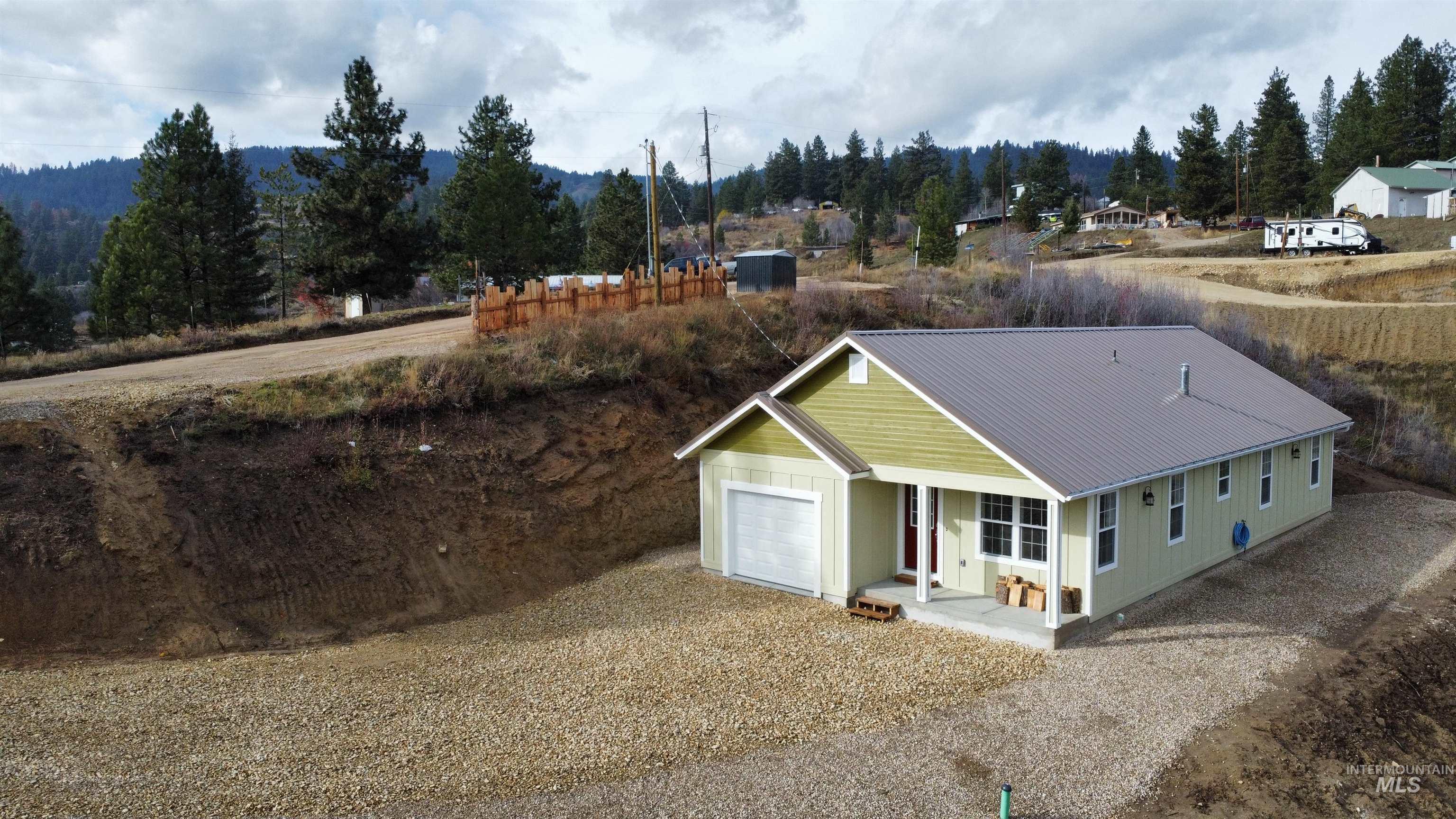 View of front of home featuring covered porch, driveway, and a metal roof