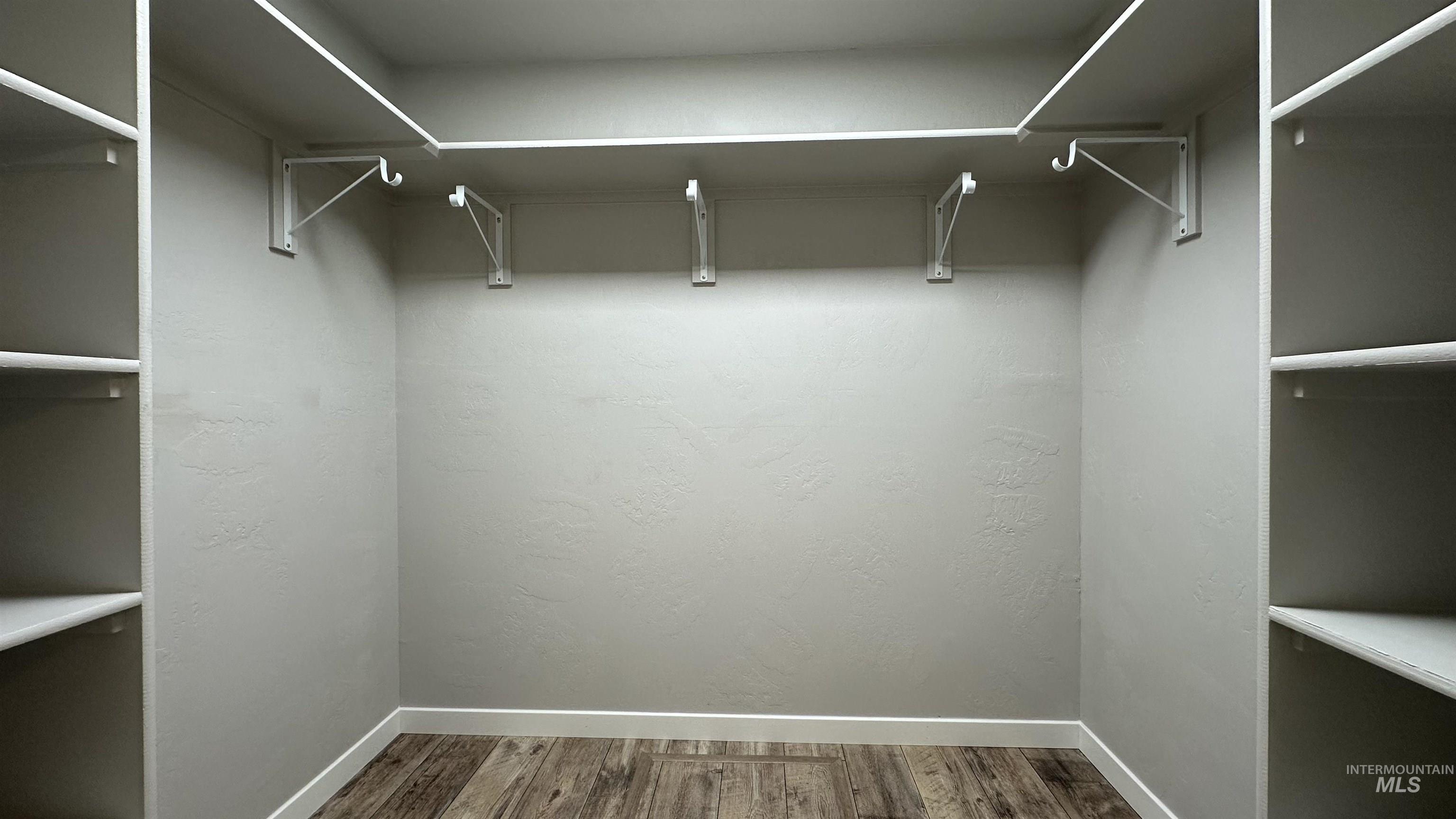 Walk in closet with wood finished floors