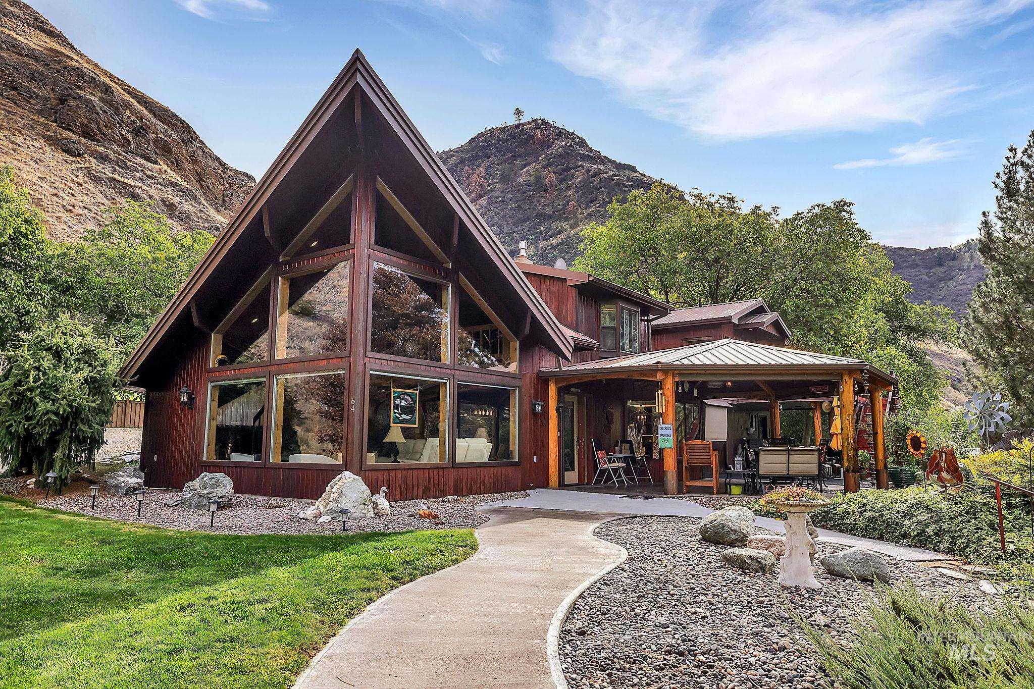 Back of property with a patio, a mountain view, a yard, a metal roof, and a standing seam roof