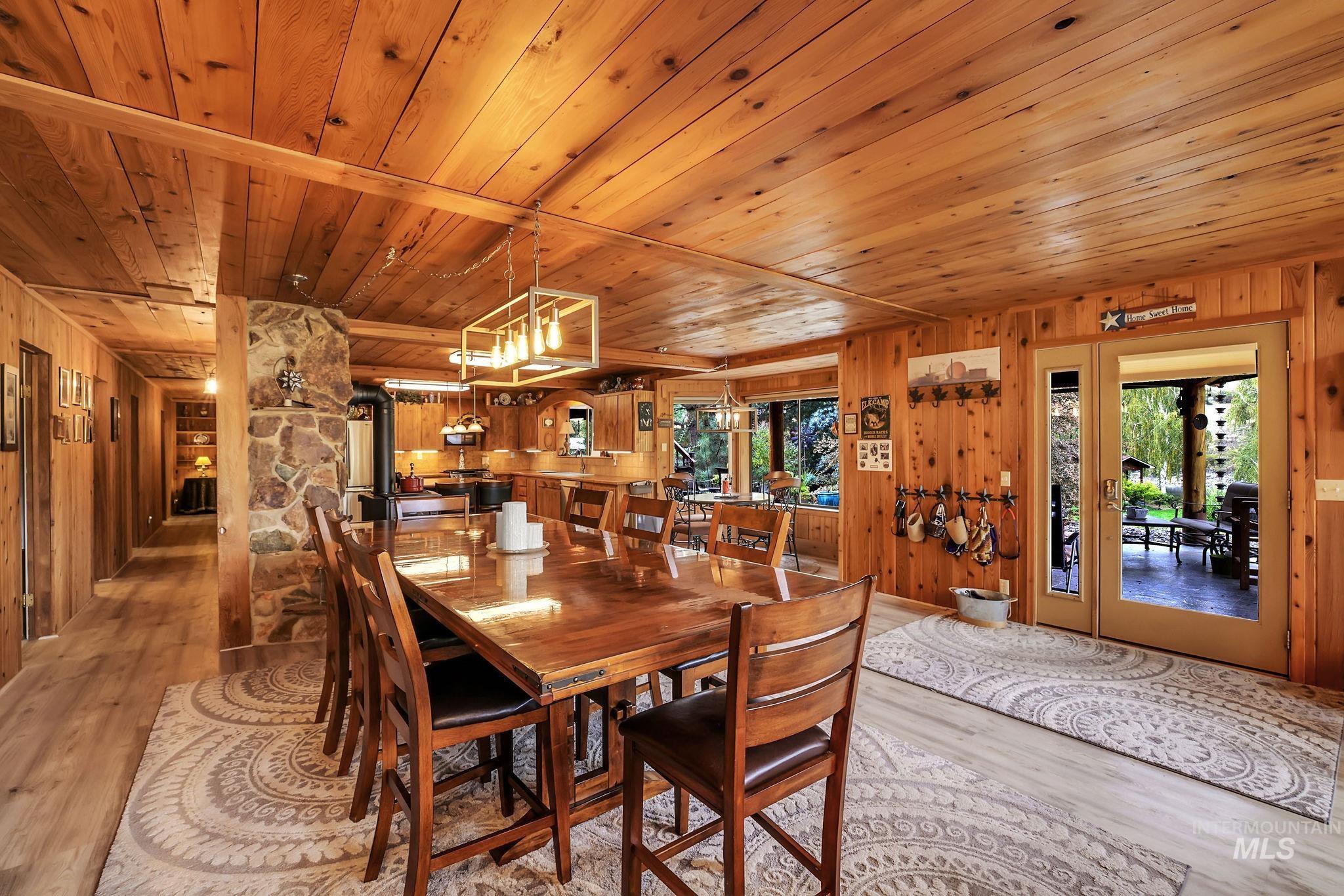 Dining space featuring wooden walls, light wood-type flooring, and wooden ceiling
