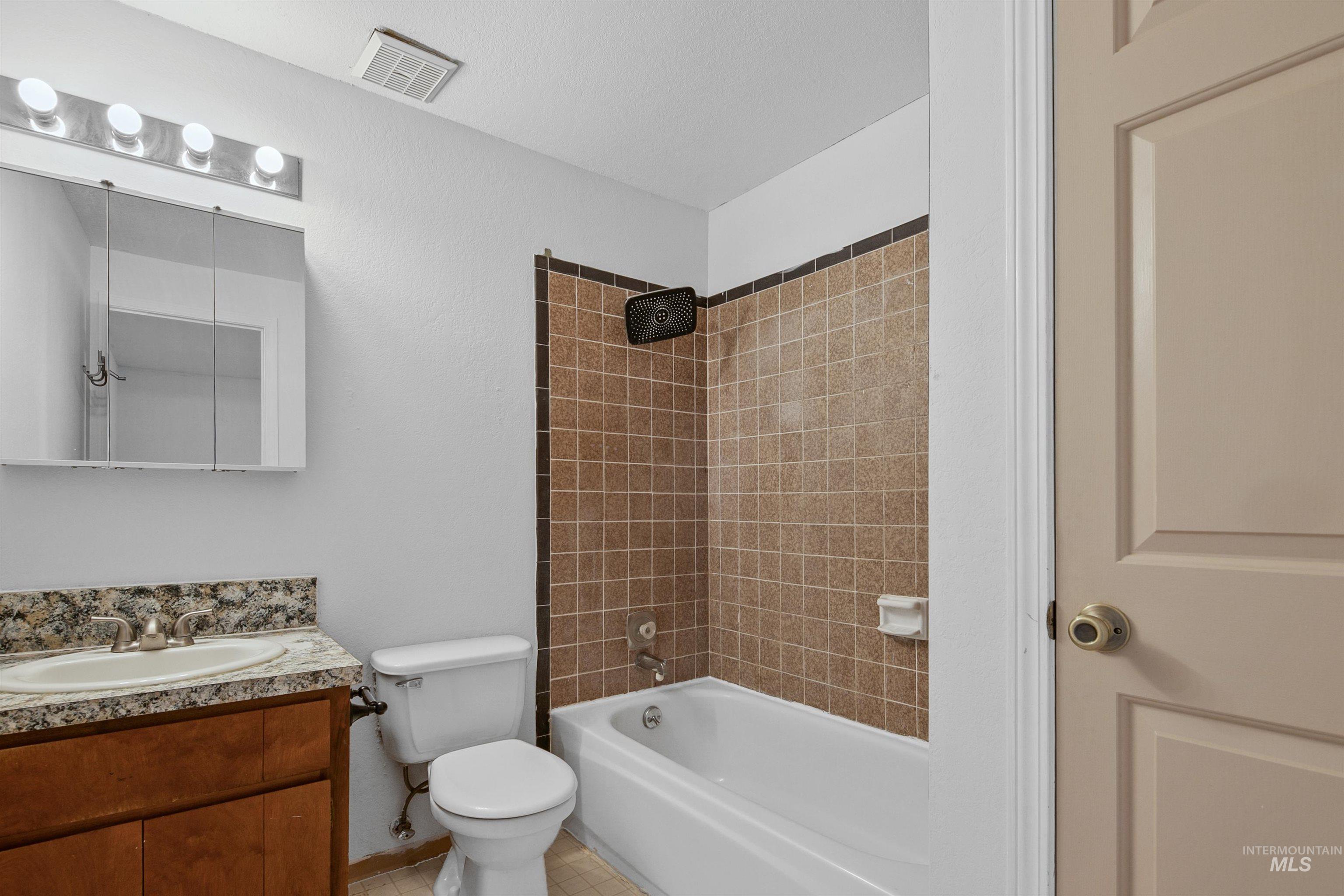 Bathroom with bathing tub / shower combination and vanity