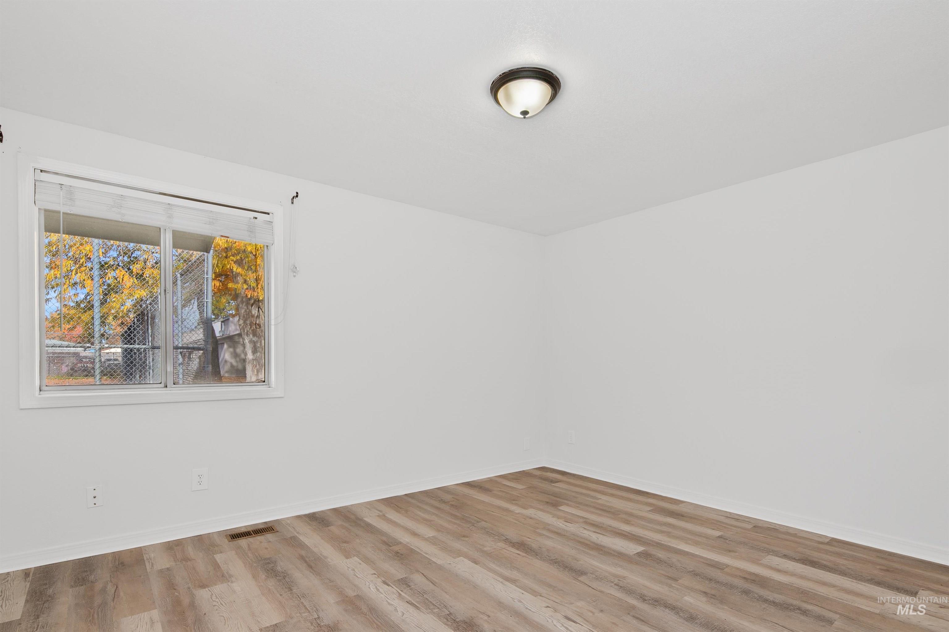 Empty room featuring wood finished floors and baseboards