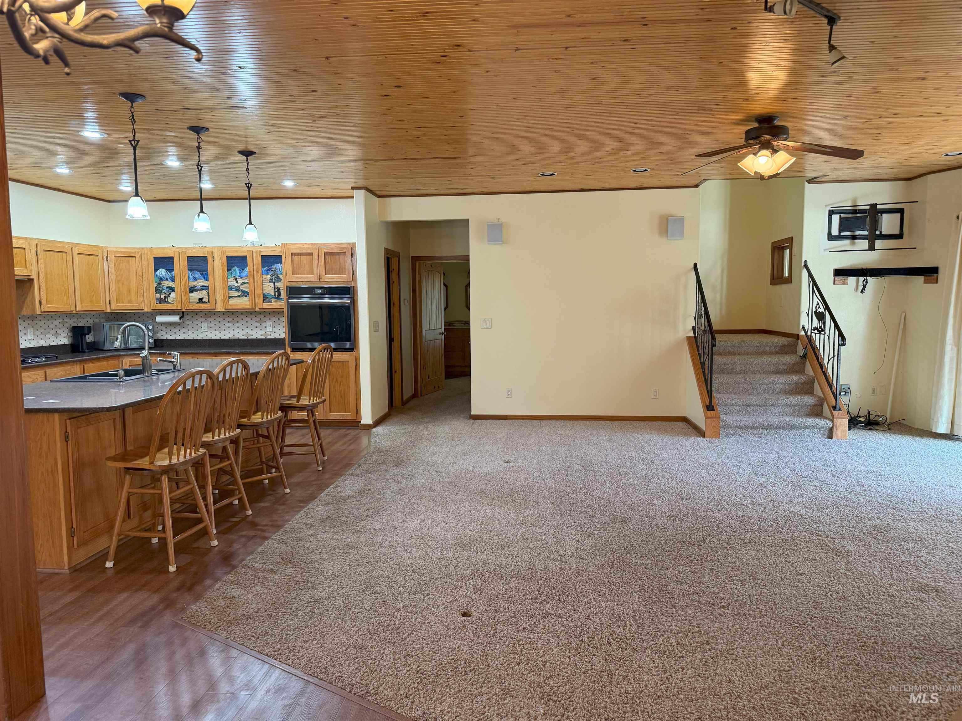 Living room featuring wooden ceiling, stairway, recessed lighting, and a ceiling fan