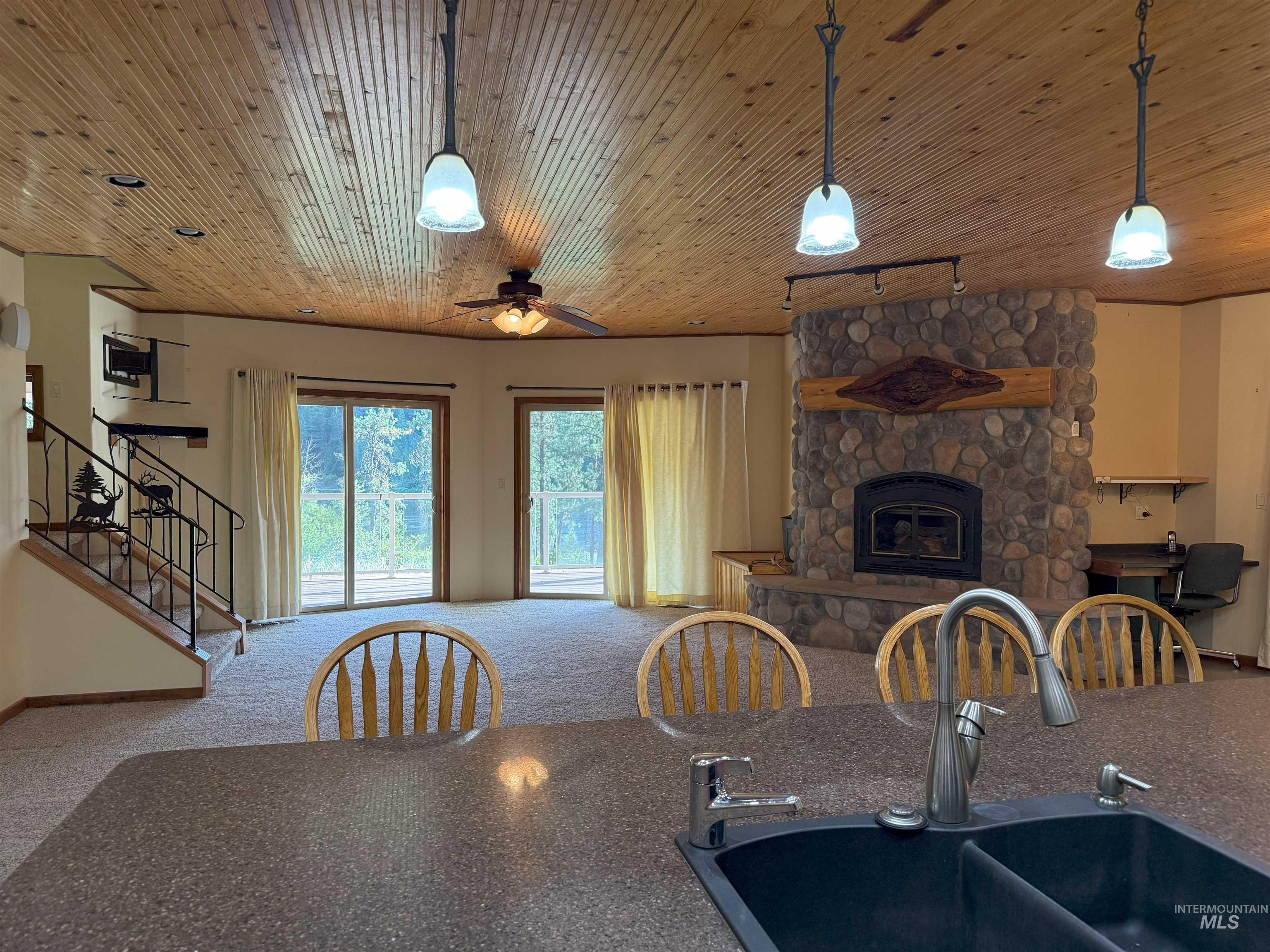 Dining area featuring track lighting, stairs, carpet floors, a fireplace, and ceiling fan