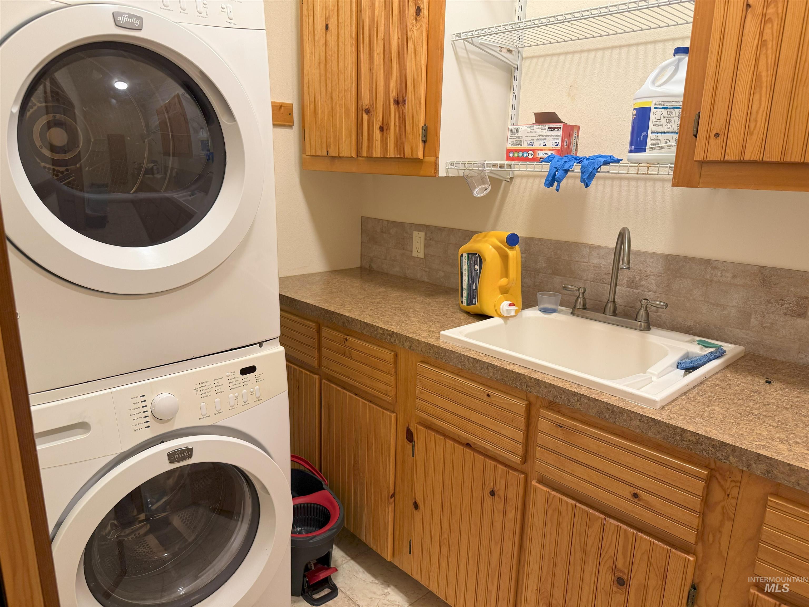 Washroom with estacked washer and dryer and cabinet space