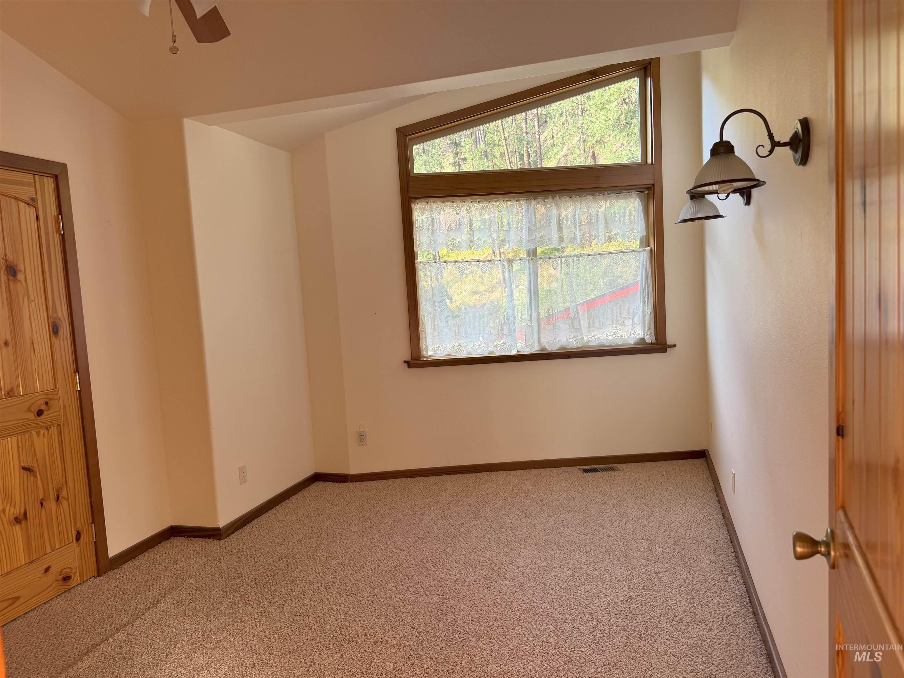 Unfurnished bedroom featuring light colored carpet and baseboards