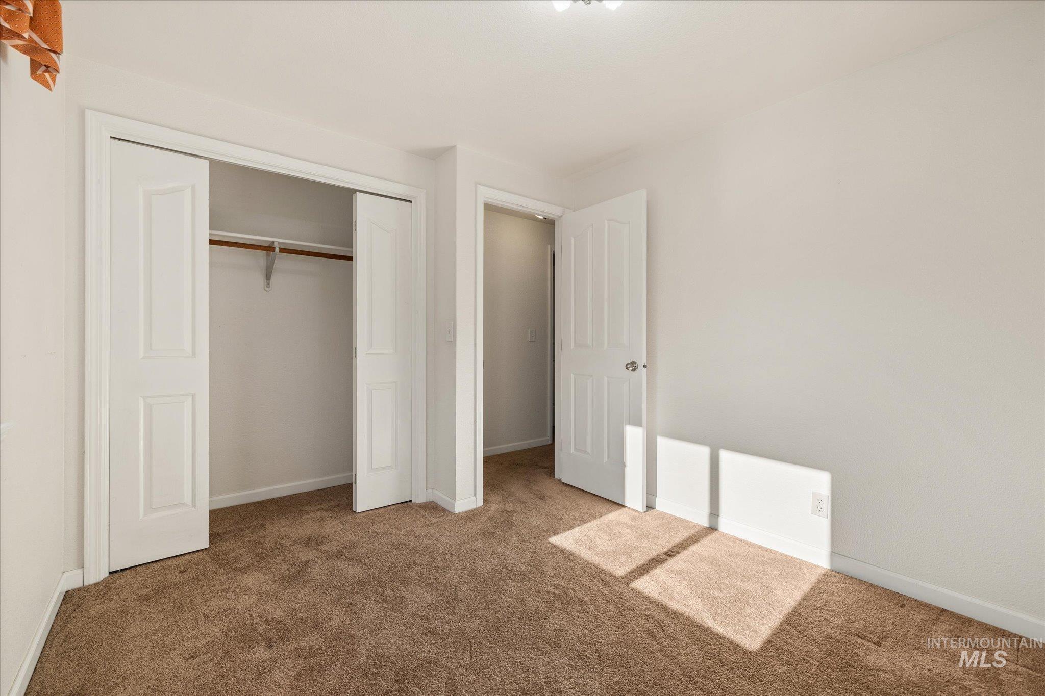 Unfurnished bedroom with carpet and a closet
